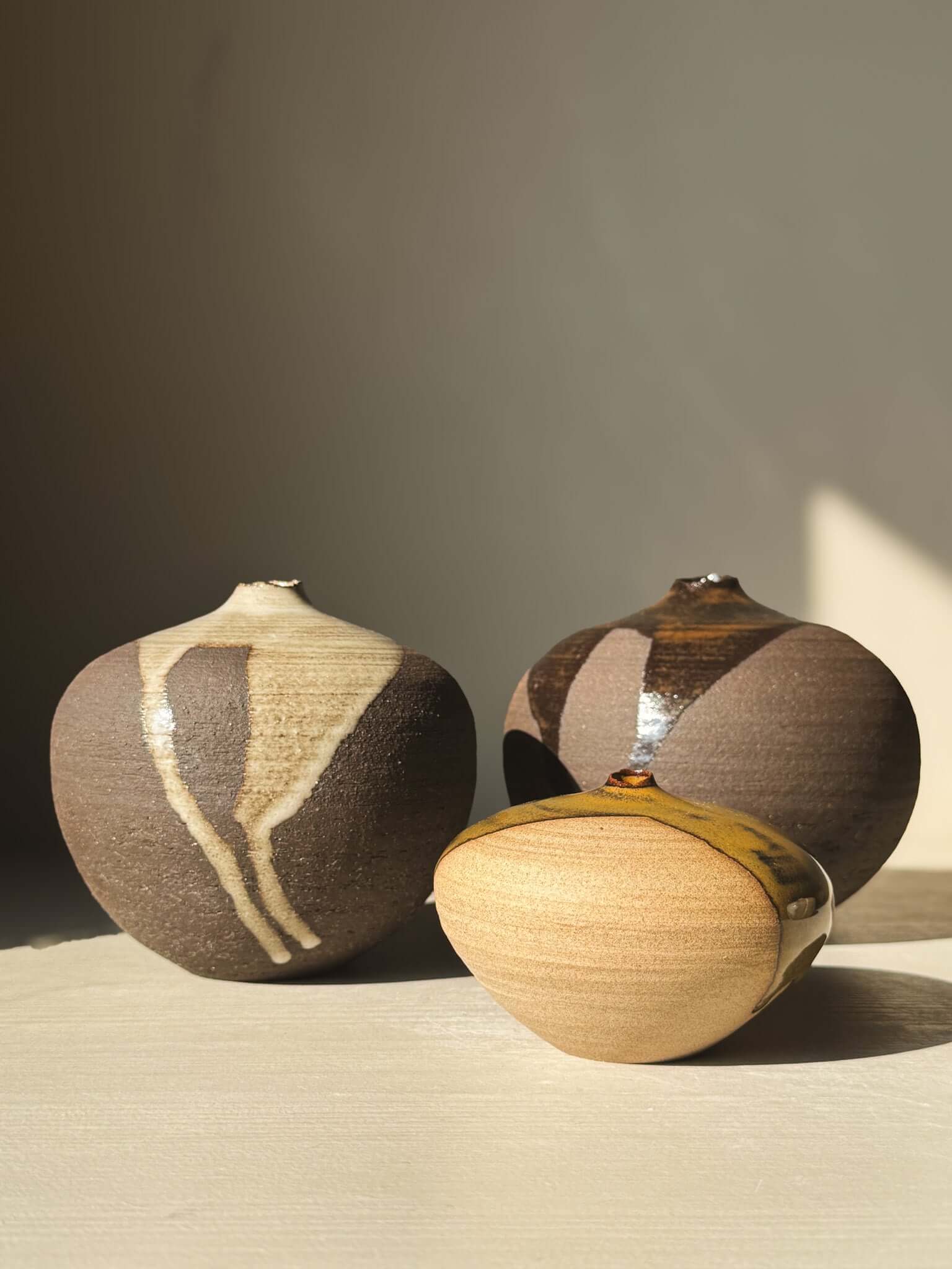 Three Orb Vase – #11 clay vases, showcasing unique glaze patterns, soft spherical forms, and earthy tones under natural light.