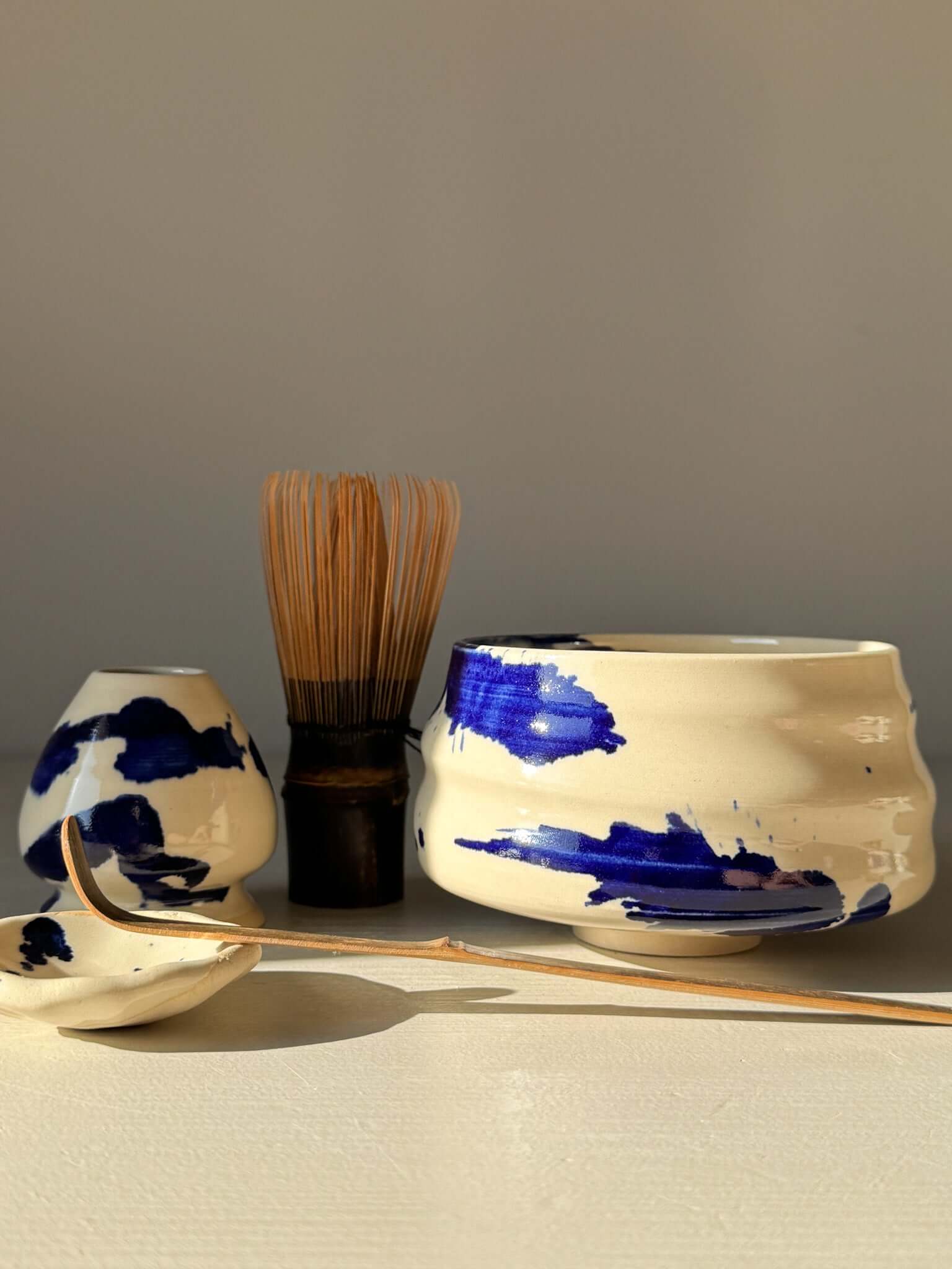 Matcha Bowl – Gosu Series #04 with cobalt glaze, tea whisk, and accessories in soft sunlight.