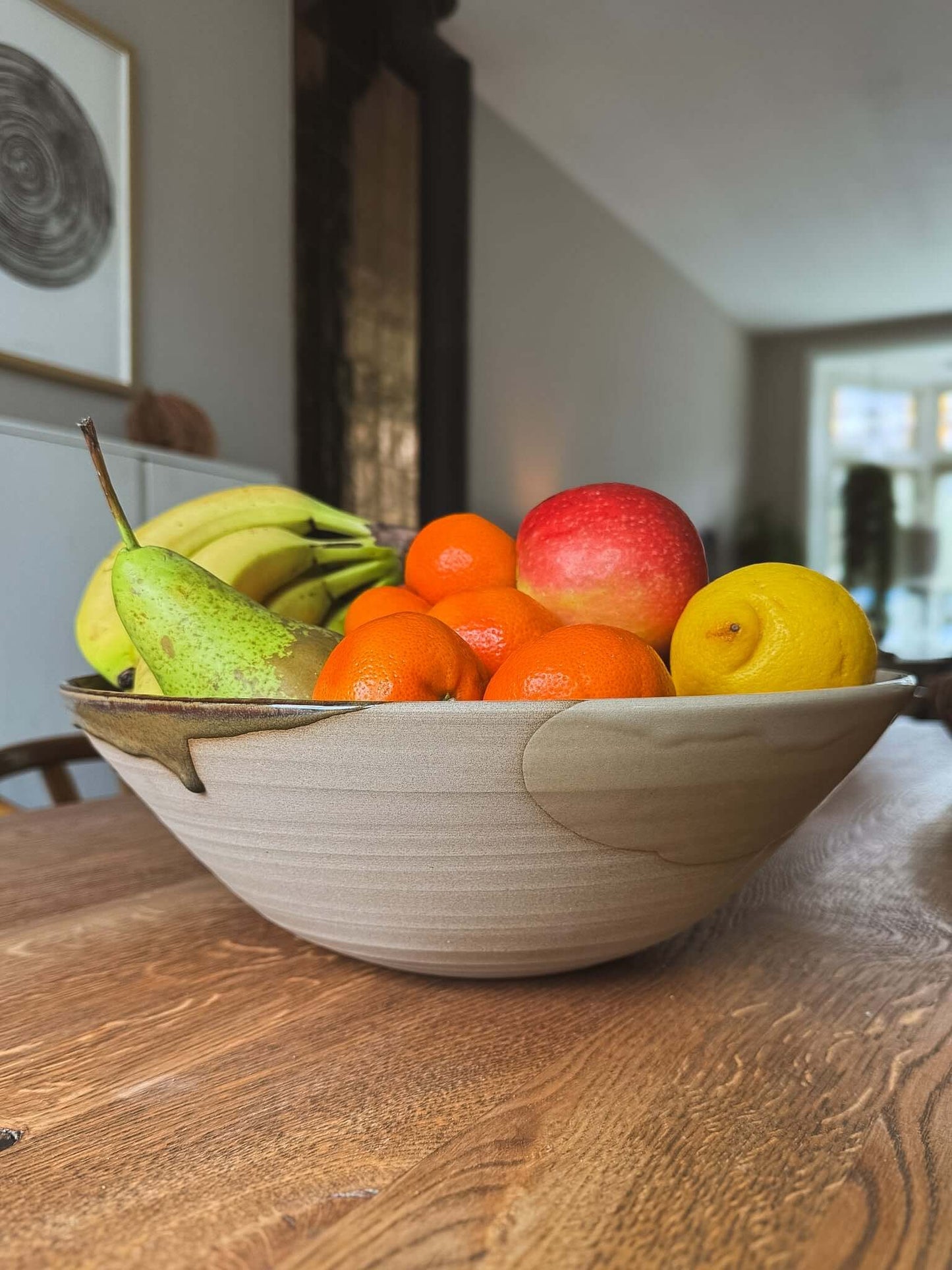 Large Bowl - Inyo #03 filled with fresh fruits including bananas, apples, lemons, and oranges, set on a wooden table.