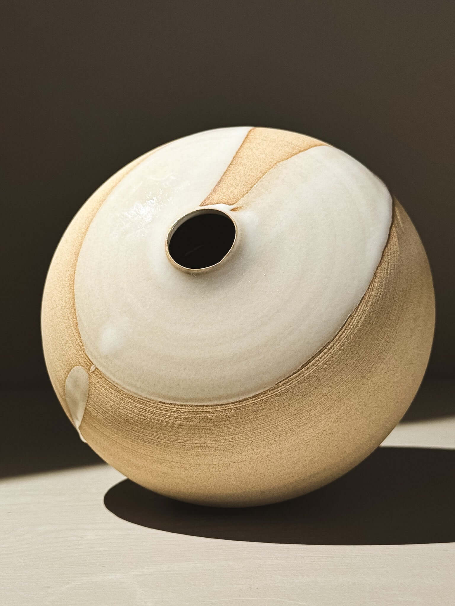Orb Vase – Yuki #03 showcasing a unique glaze pattern and soft spherical form on a minimalist backdrop.