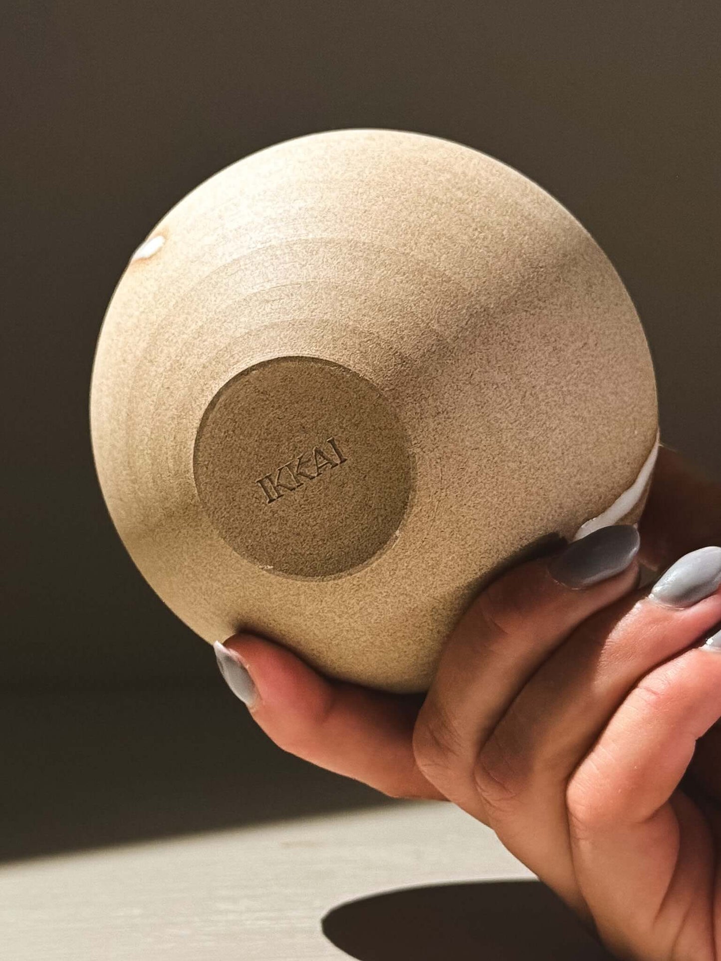 Orb Vase – Yuki #07 held elegantly, showcasing its smooth surface and unique glaze detailing.