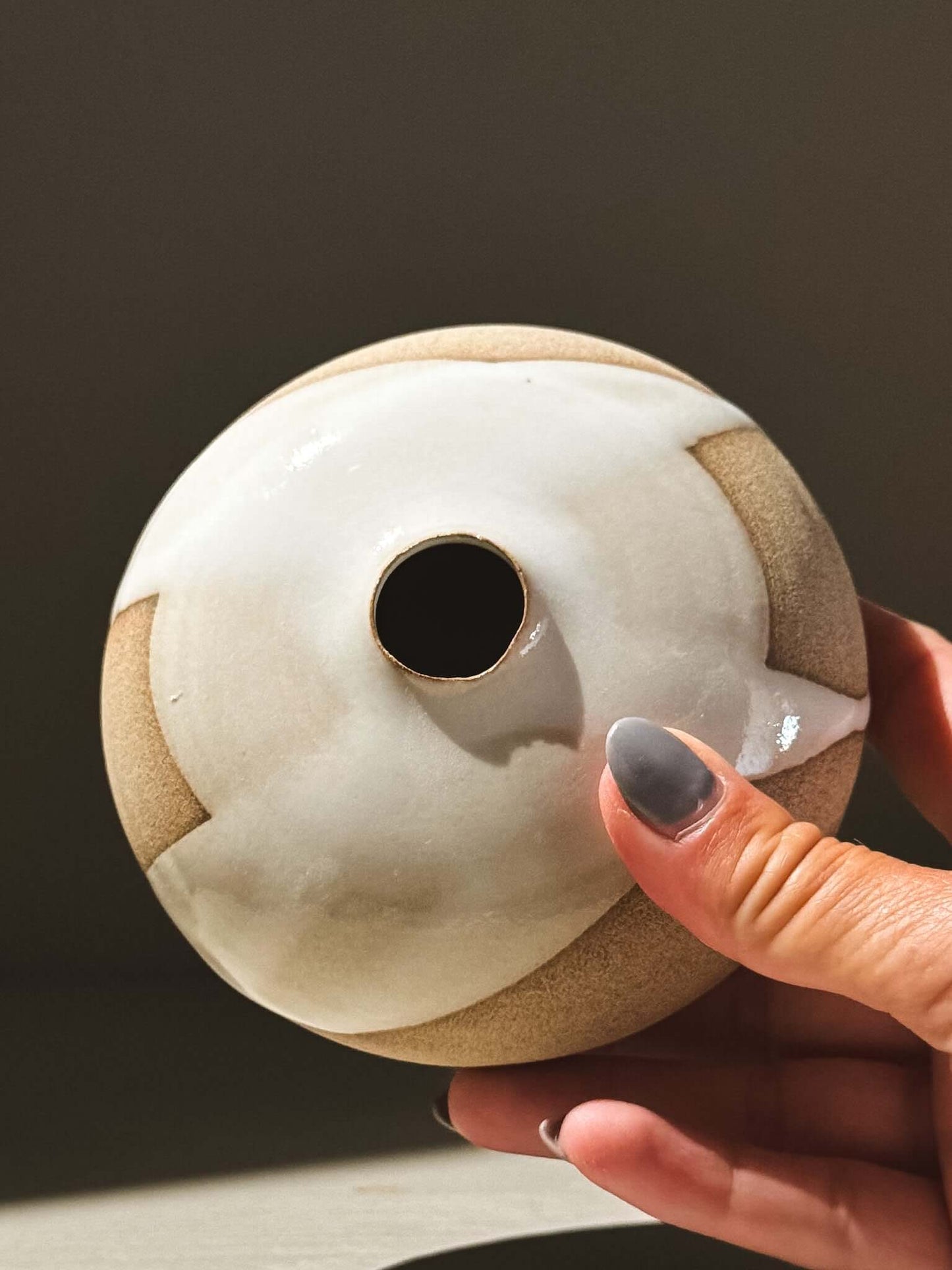 Hand holding the Orb Vase – Yuki #08 showcasing its unique glaze and rounded form.