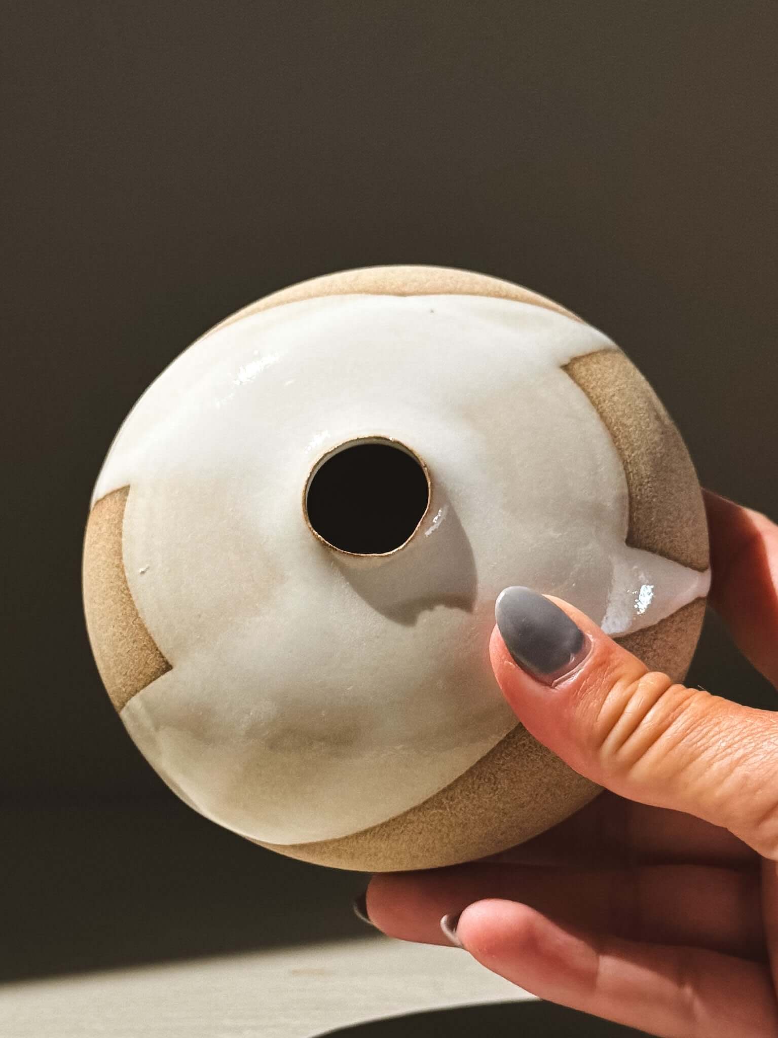 Hand holding the Orb Vase – Yuki #08 showcasing its unique glaze and rounded form.