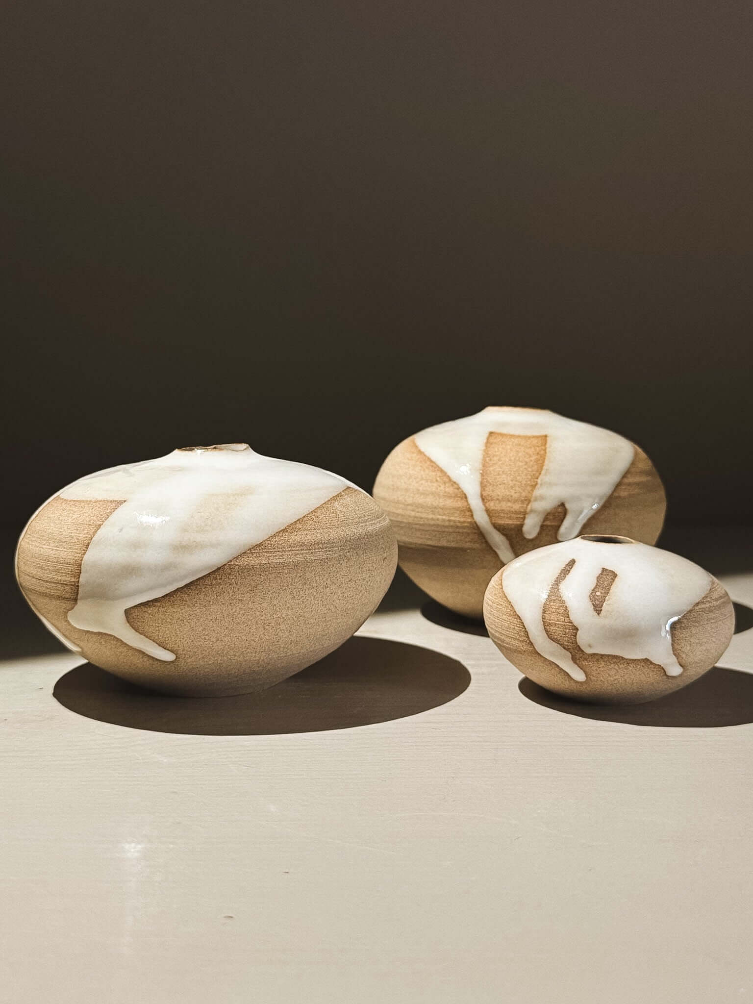 Orb Vase – Yuki #08, a trio of rounded vases with unique glaze patterns and soft, sculptural forms.