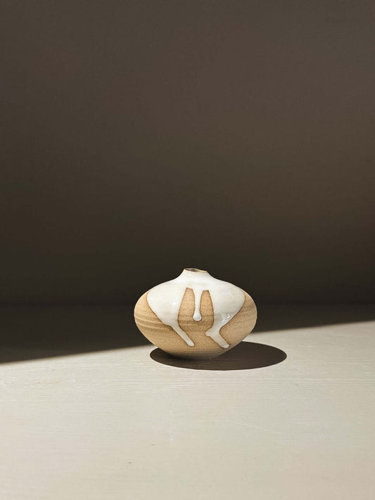 Orb Vase – Yuki #09 in soft spherical form with unique glaze patterns casting shadows on a surface.