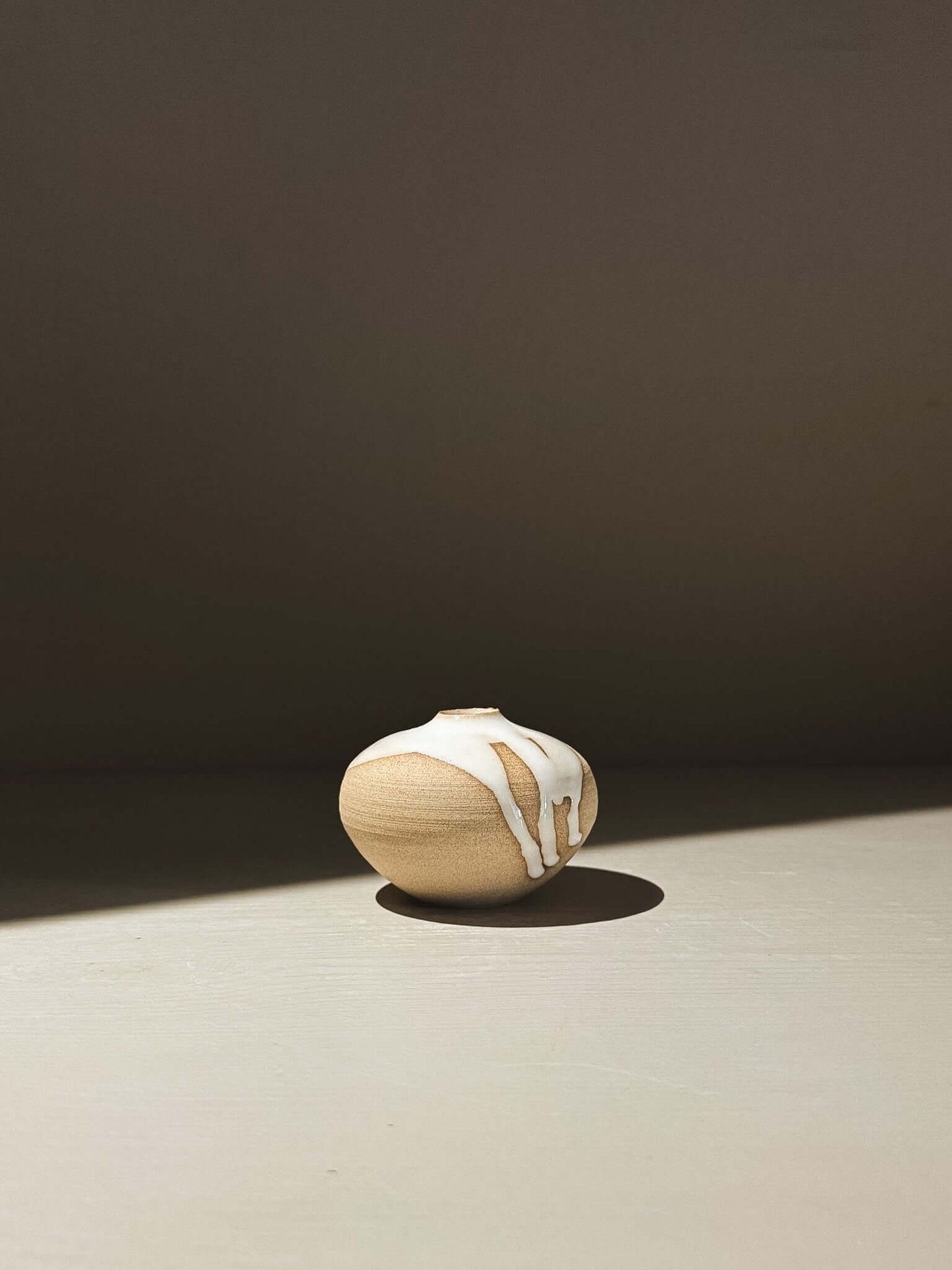 Orb Vase – Yuki #11 showcasing its unique glaze and rounded design in a natural light setting.
