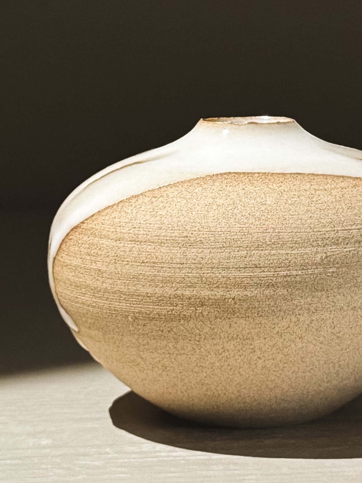Orb Vase – Yuki #11 with a beige and white glaze, showcasing its unique rounded shape and gentle patterns.