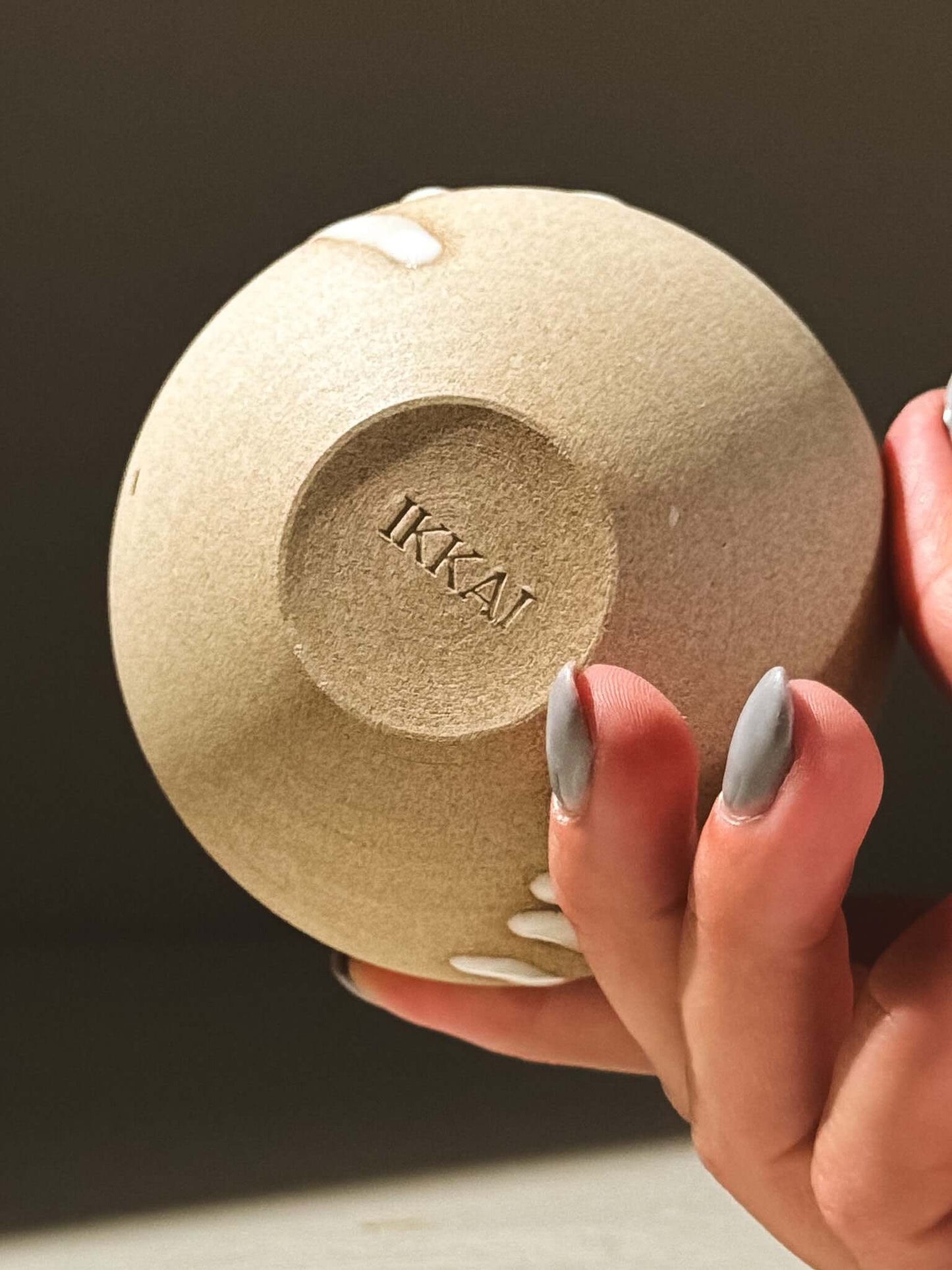 Close-up of the base of an IKKAI orb vase, showcasing its unique glazed texture and handcrafted details.