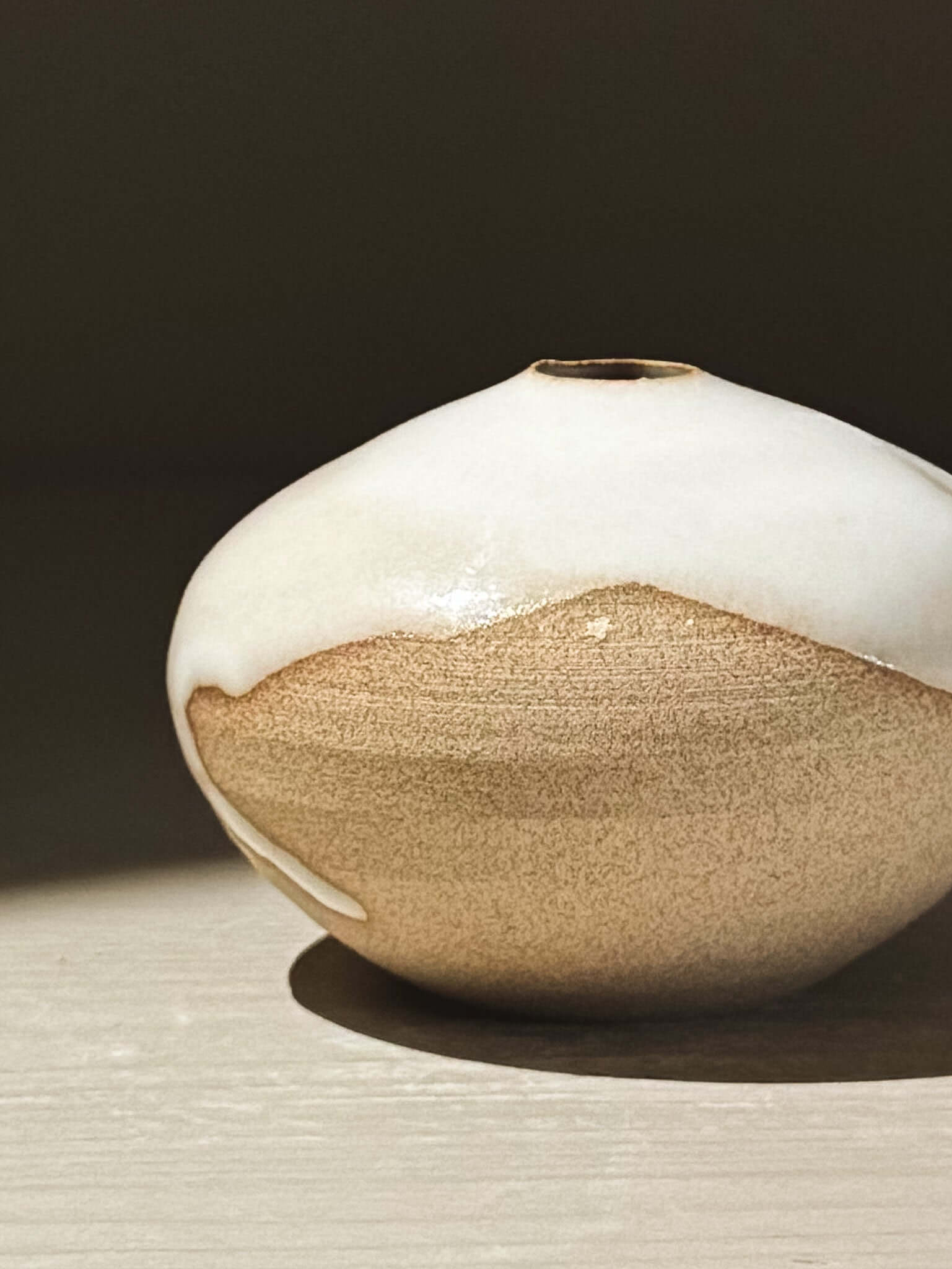 Orb Vase – Yuki #12 with a smooth white and golden-glazed surface showcasing unique organic patterns.