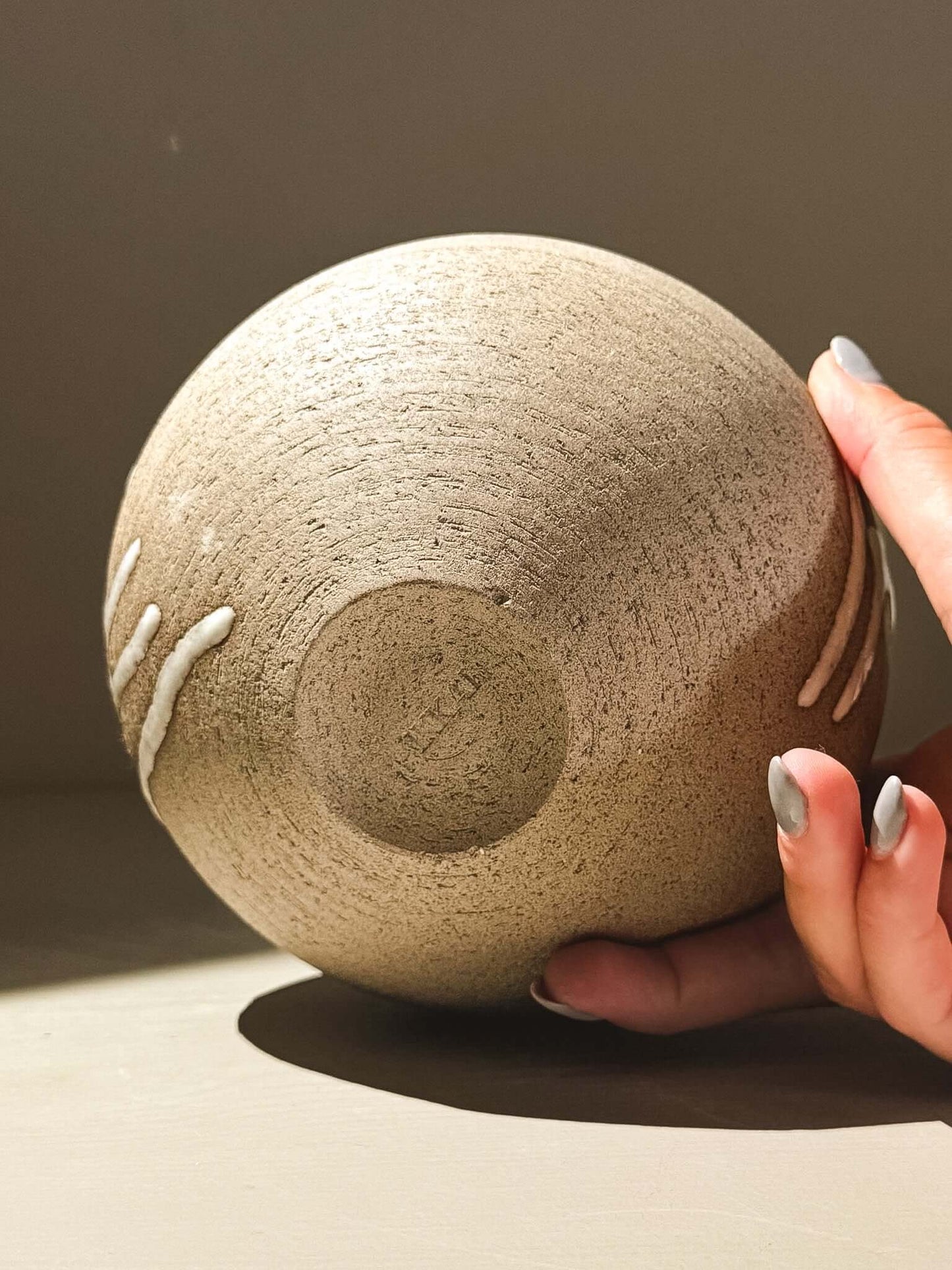 Orb Vase – Yuki Ash #01 held in hand, showcasing unique glaze and smooth spherical design.