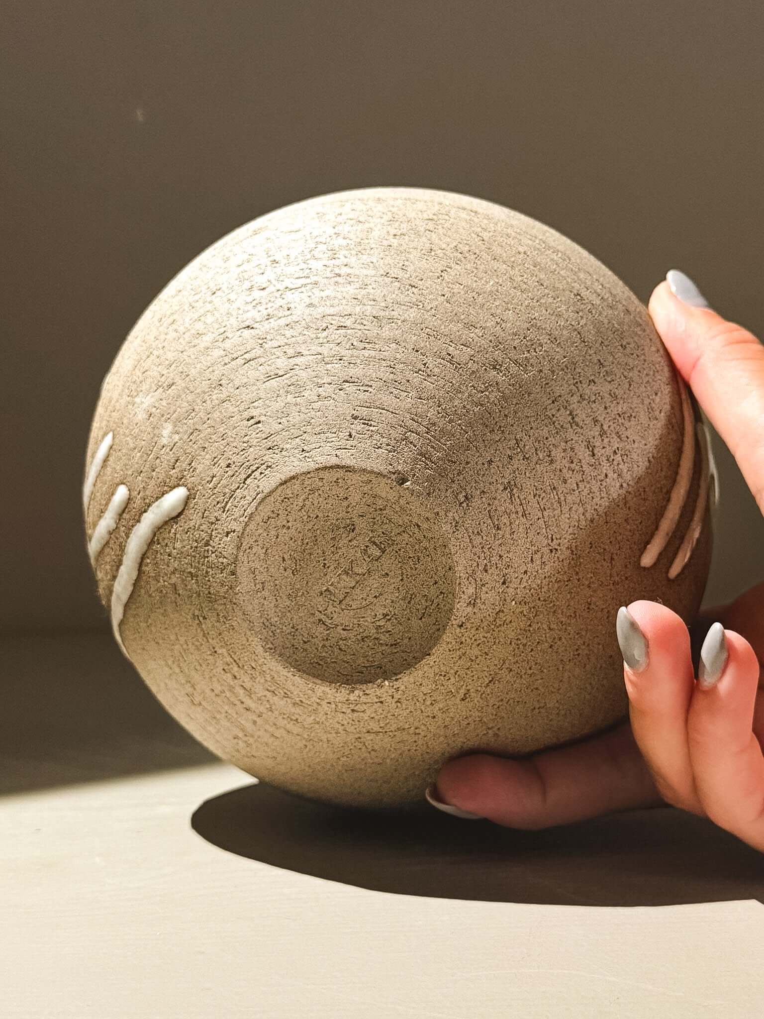 Orb Vase – Yuki Ash #01 held in hand, showcasing unique glaze and smooth spherical design.