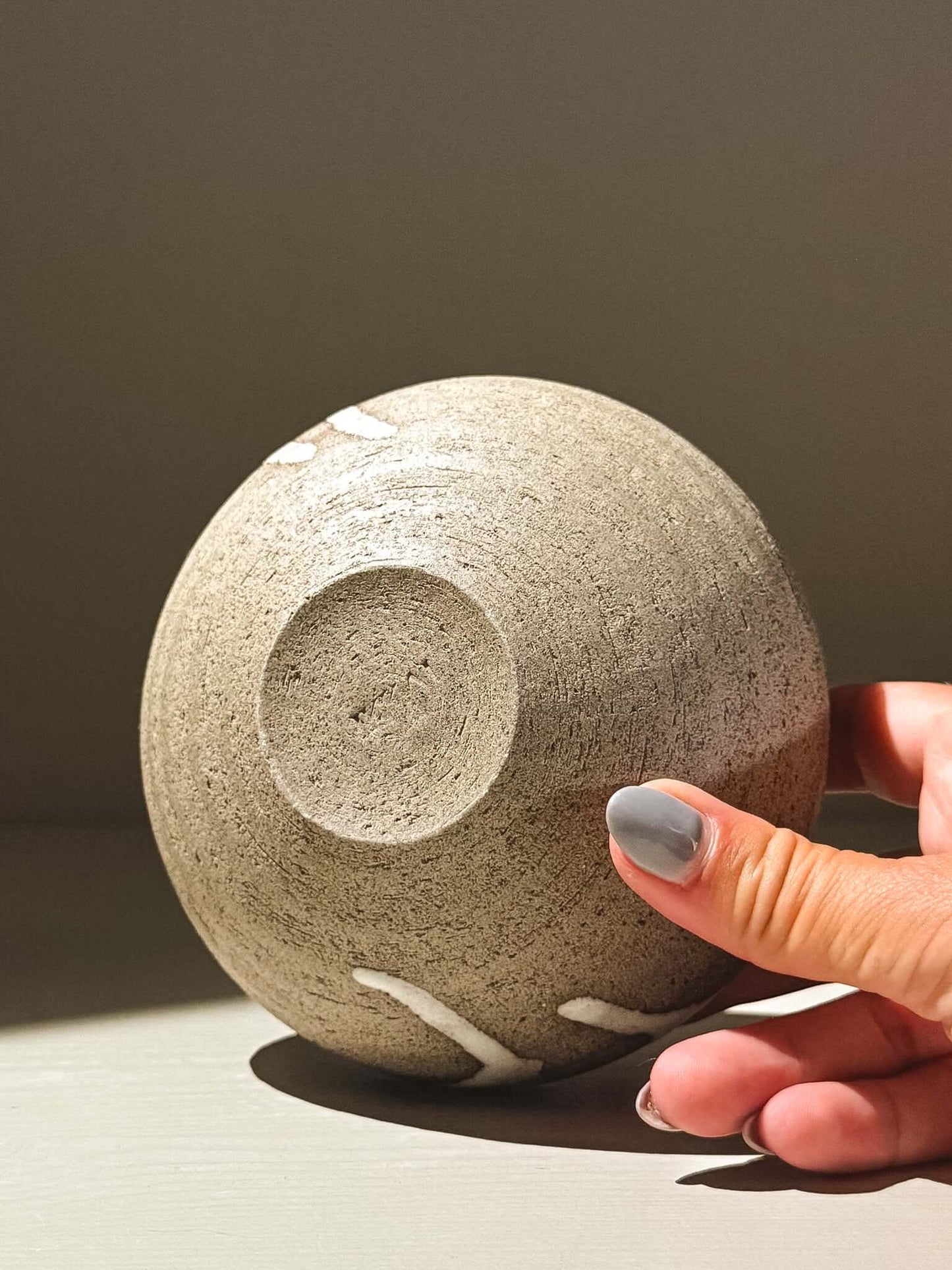 Orb Vase – Yuki Ash #03 held in hand, showcasing unique organic patterns and soft spherical form.