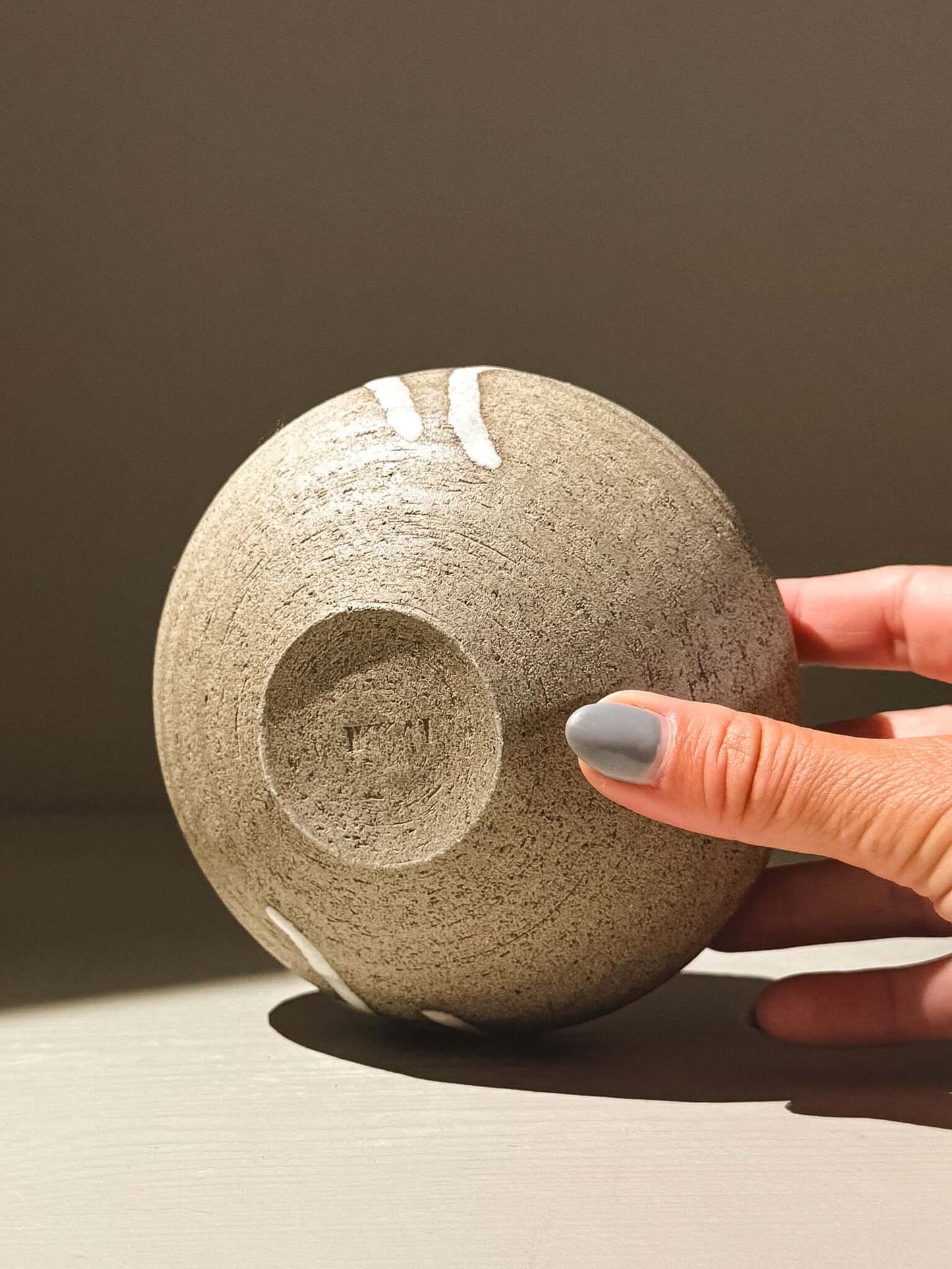 Orb Vase – Yuki Ash #05 held in a hand, showcasing the unique glaze and organic patterns of the pottery.