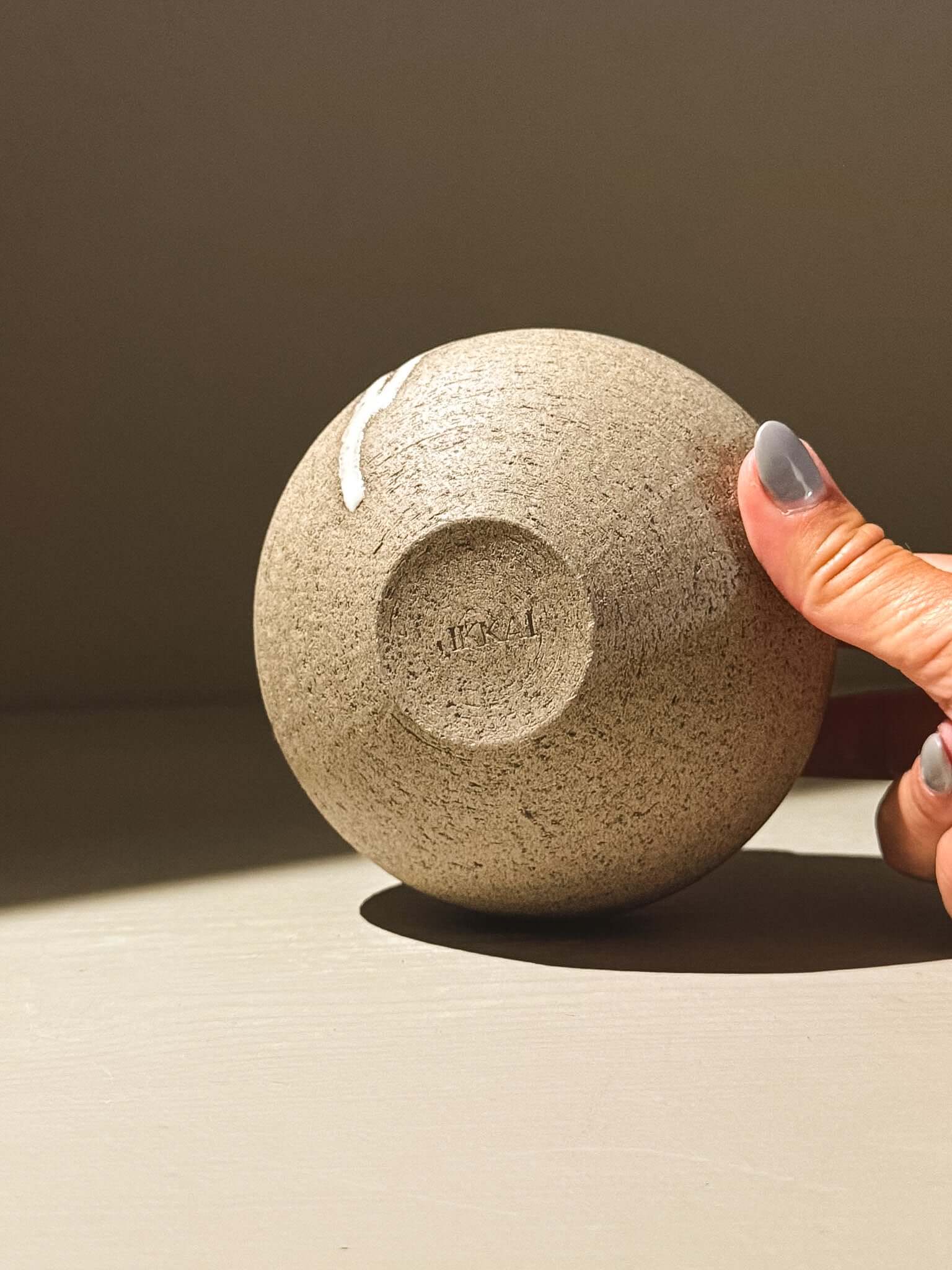 Orb Vase – Yuki Ash #06 showcasing unique glaze patterns and soft spherical form, held elegantly in hand.