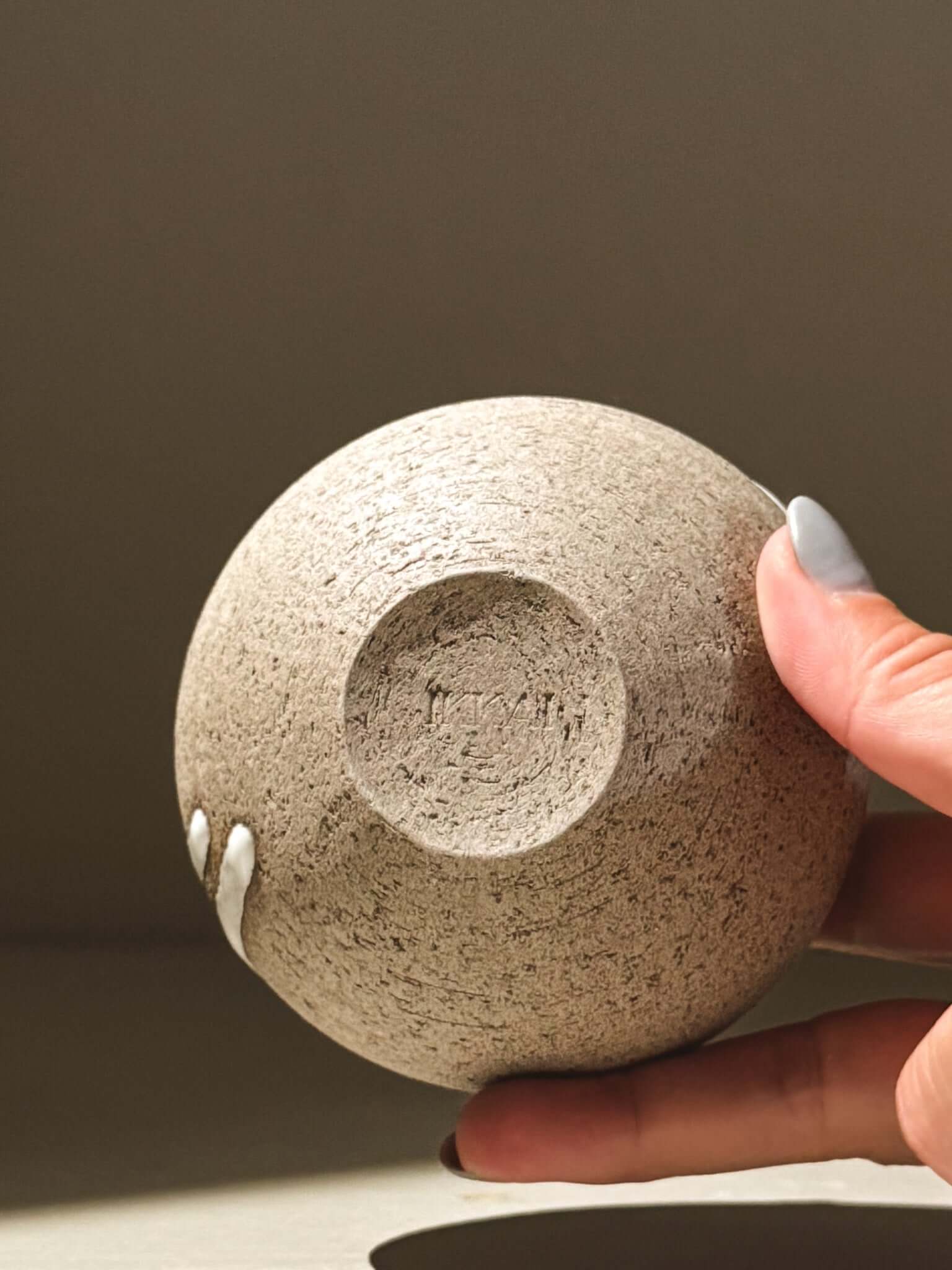 Orb Vase – Yuki Ash #12 held in hand, showcasing unique texture of the japnese handmade ceramic orb vase.