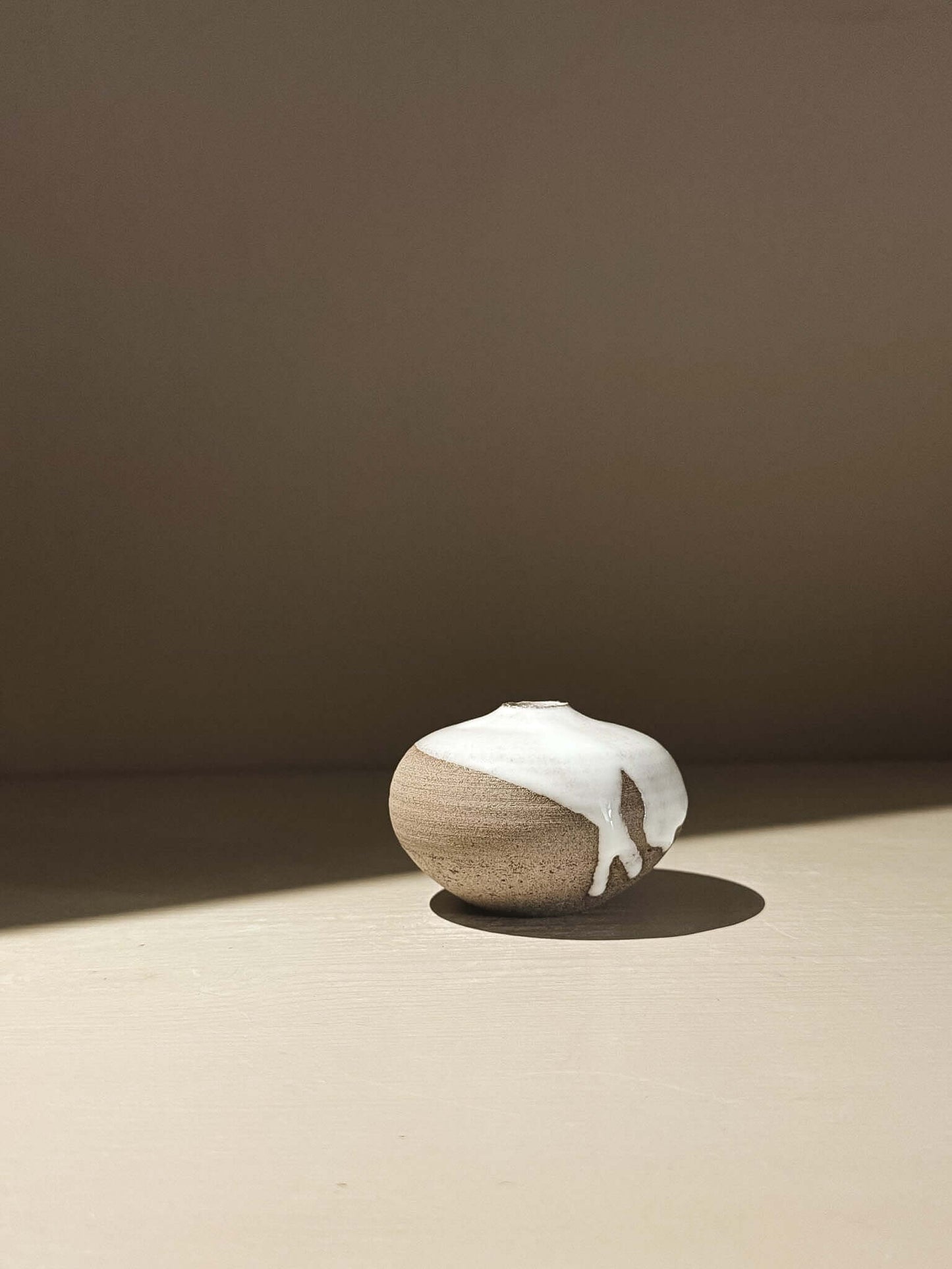 Handmade ceramic Japanese orb vase in Yuki Ash #14 with natural glaze movement and soft, rounded shape.