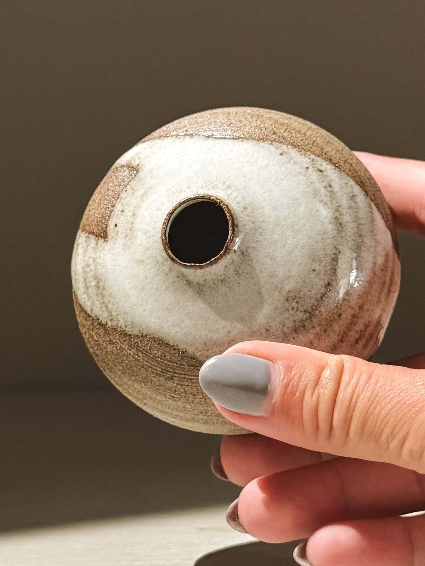 Handmade ceramic Japanese orb vase, Orb Vase – Yuki Ash #16, showcasing unique glaze patterns and soft spherical shape.
