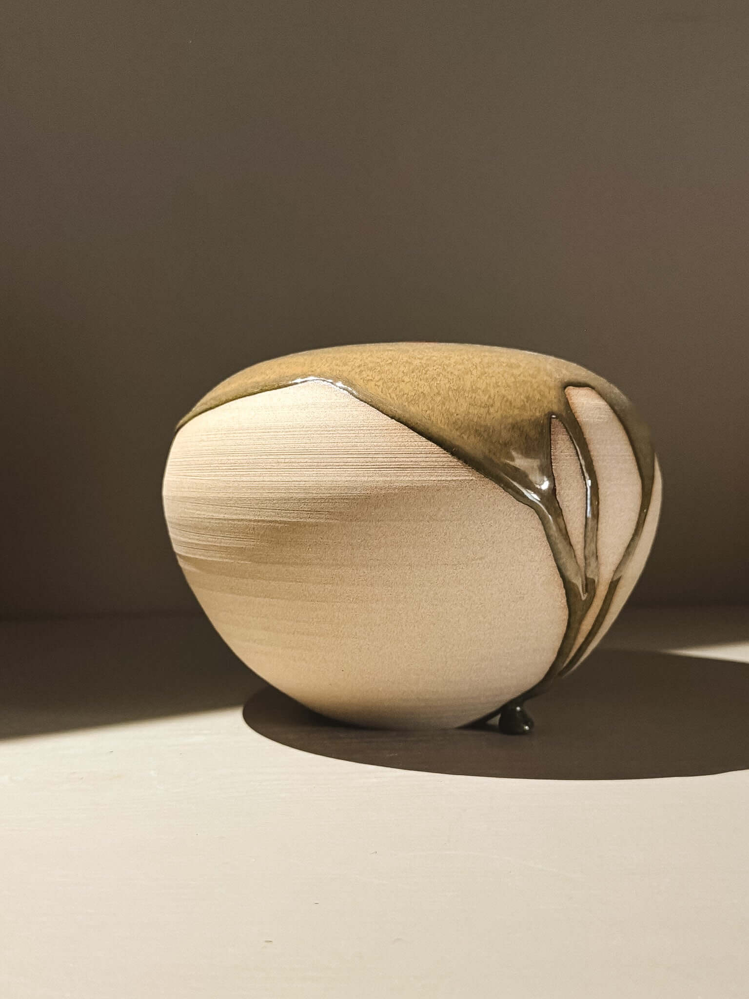 Handmade ceramic Japanese orb vase, Orb Vase – Tenmoku #02, with unique glaze patterns and soft spherical form.