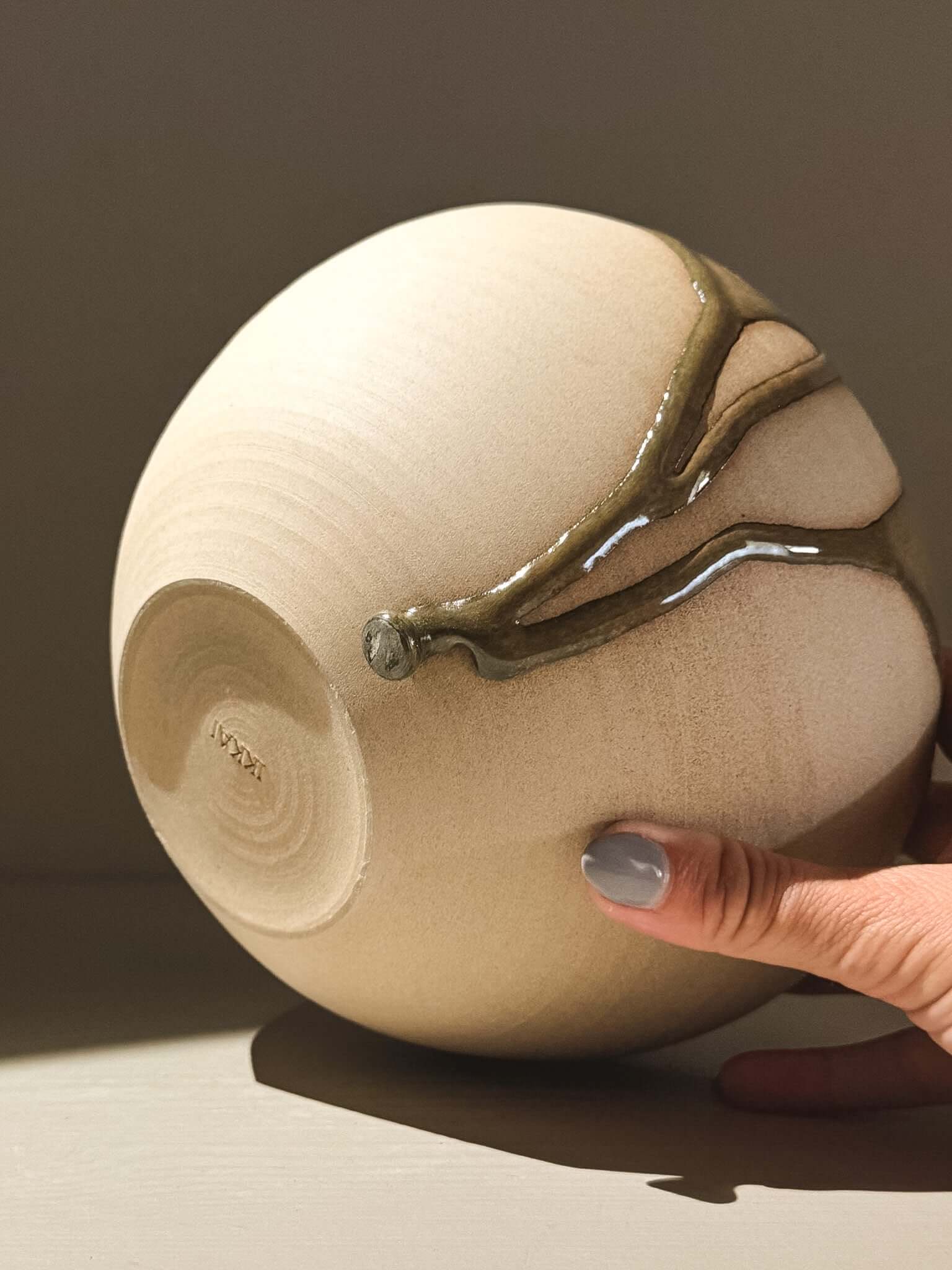Handmade ceramic Japanese orb vase, Orb Vase – Tenmoku #02 showcasing a unique glaze and soft spherical form.