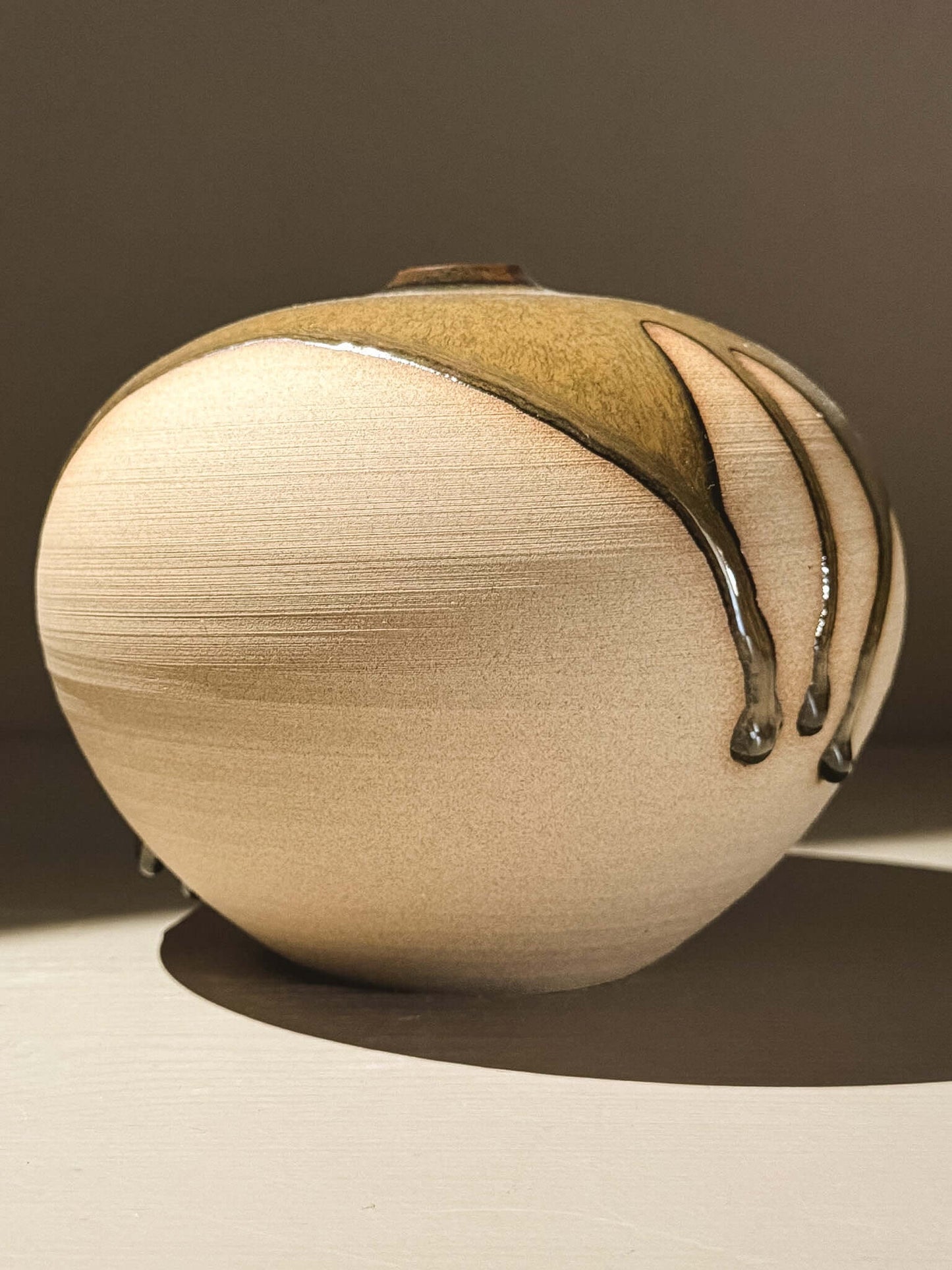Handmade ceramic Japanese orb vase, Orb Vase – Tenmoku #03 showcasing unique glaze movement and soft spherical form.
