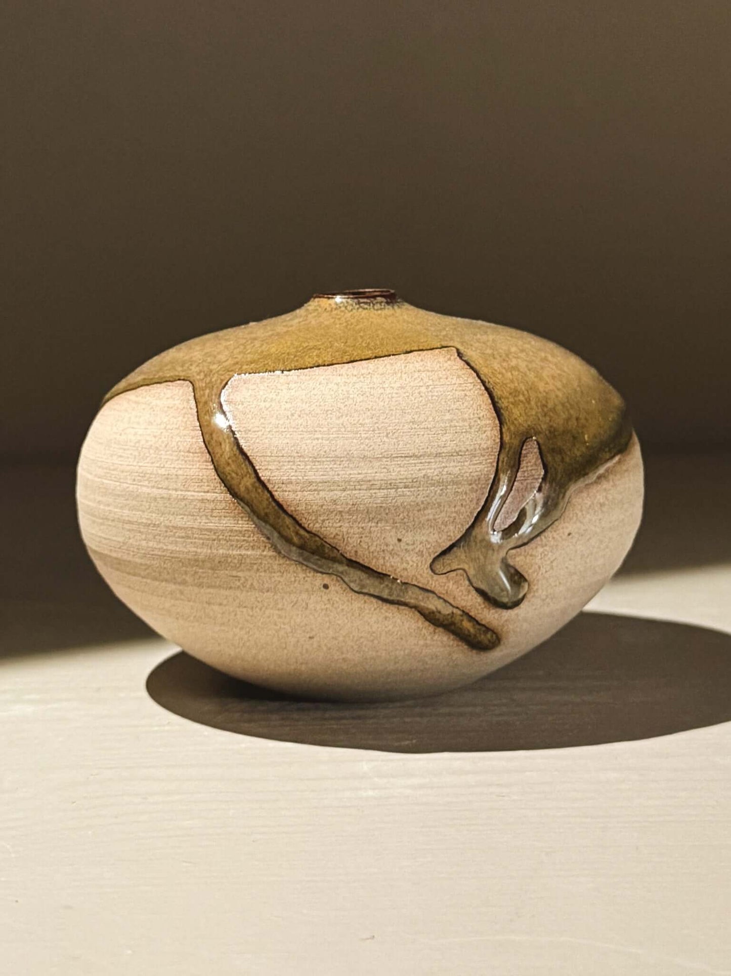 Orb Vase – Tenmoku #07 showcasing unique glaze movement and rounded clay design, adding sculptural elegance.