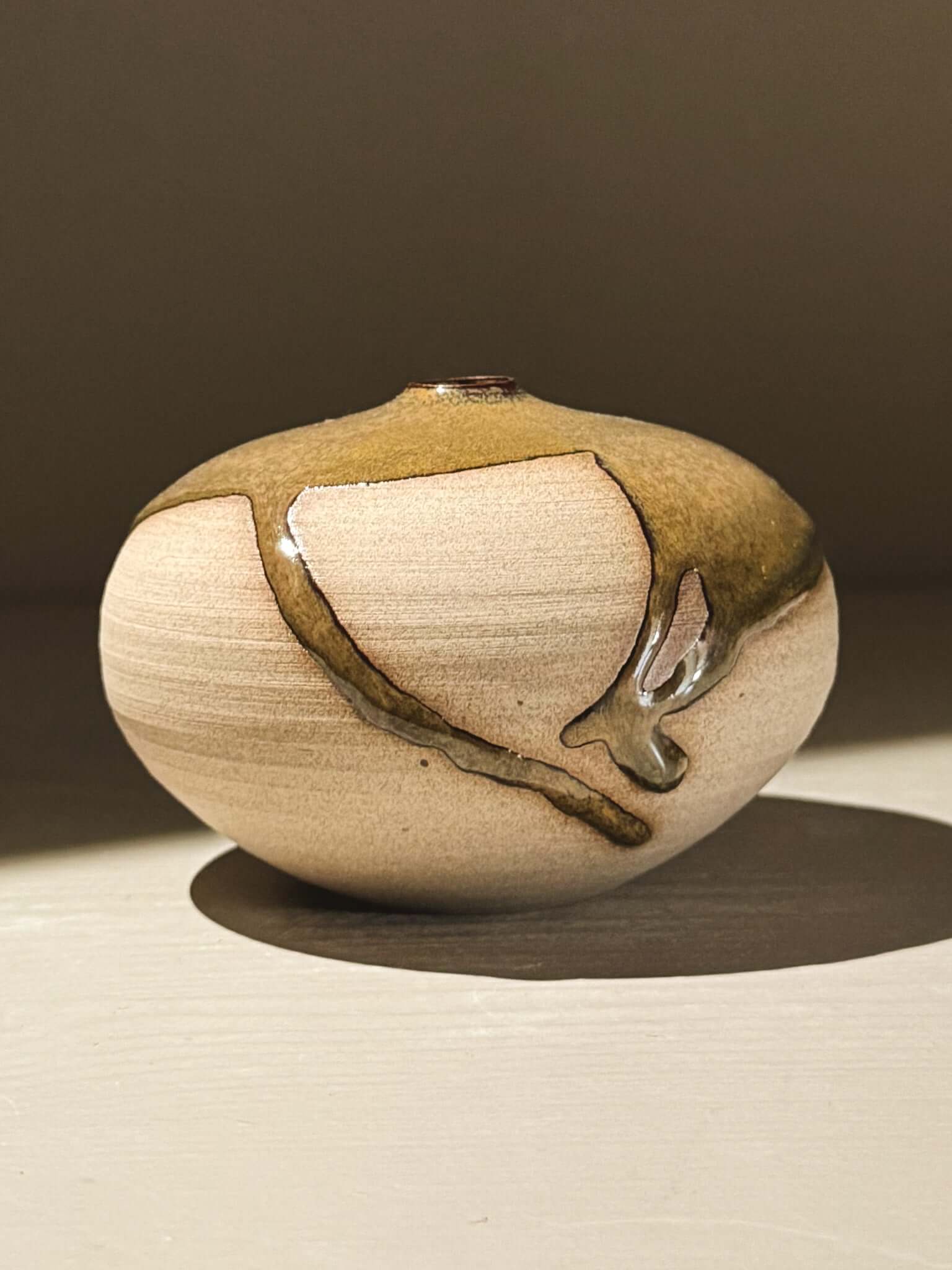 Orb Vase – Tenmoku #07 showcasing unique glaze movement and rounded clay design, adding sculptural elegance.