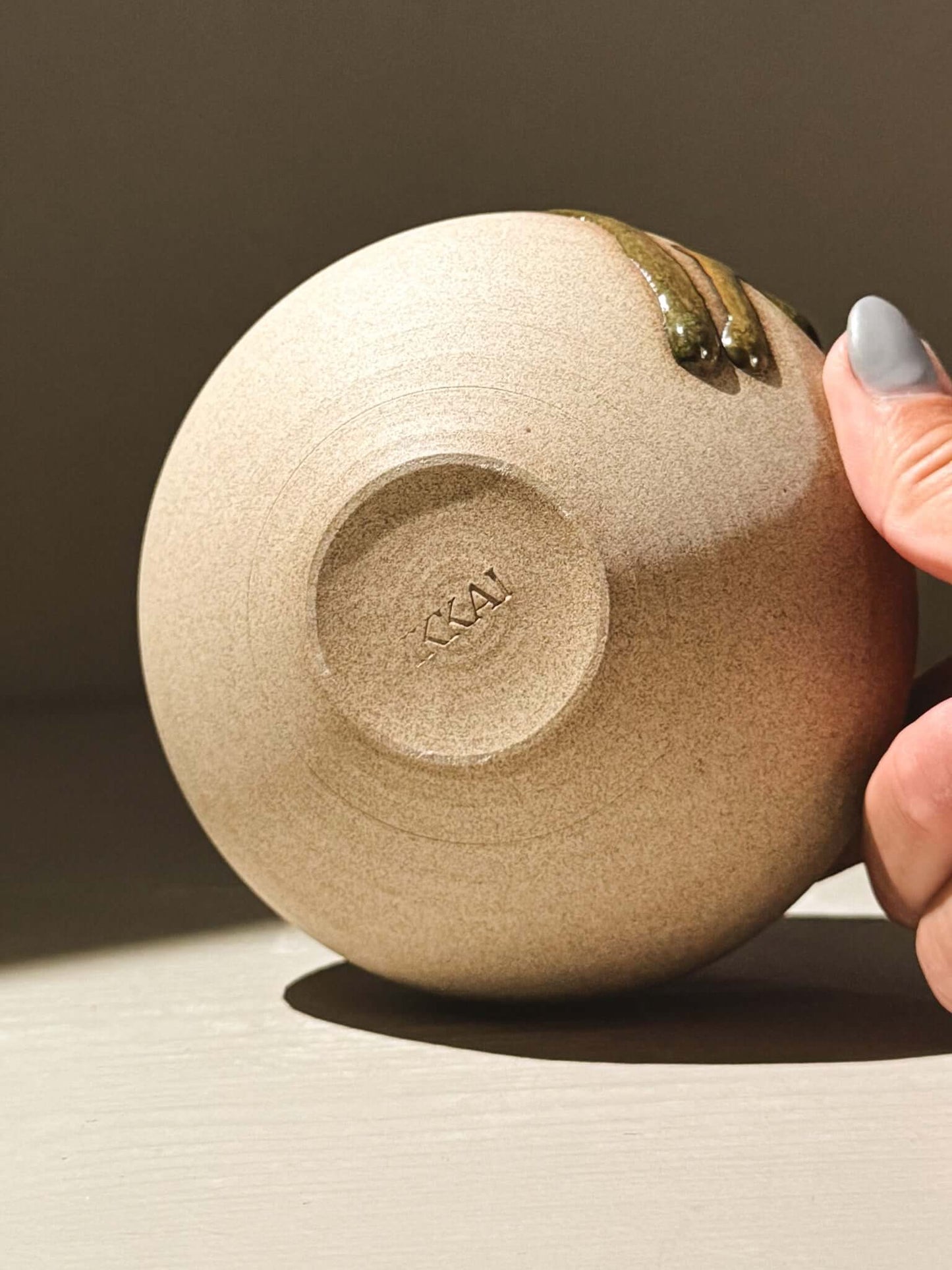 Close-up of the underside of the handmade ceramics Orb Vase – Tenmoku #08, showcasing its unique glaze and craftsmanship.