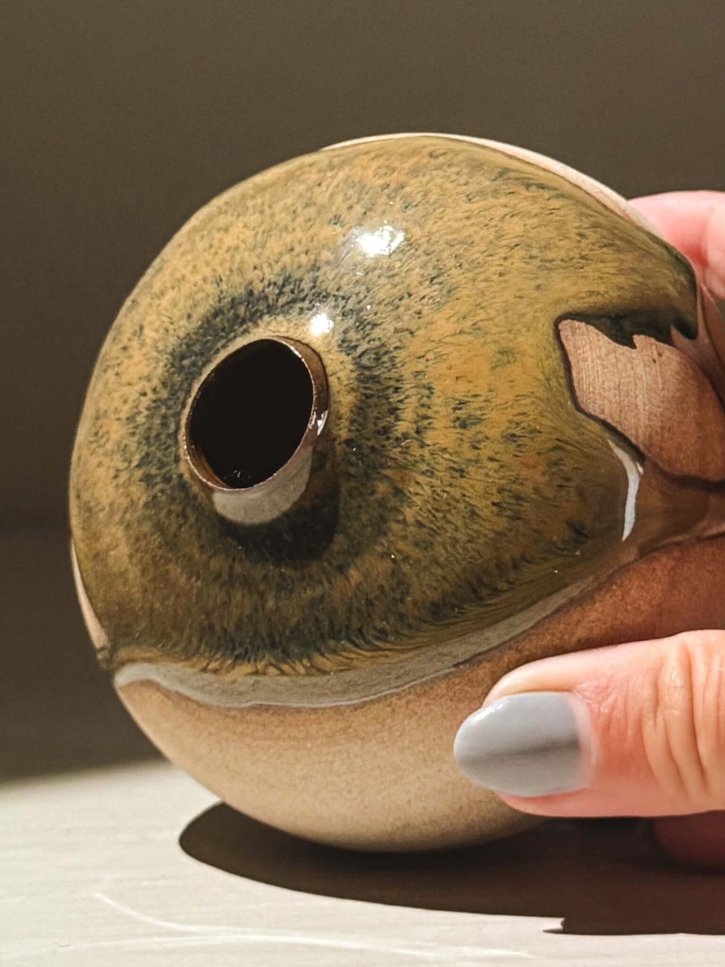 Handmade ceramics orb vase – Tenmoku #09 showing unique glaze patterns and rounded form in close-up.