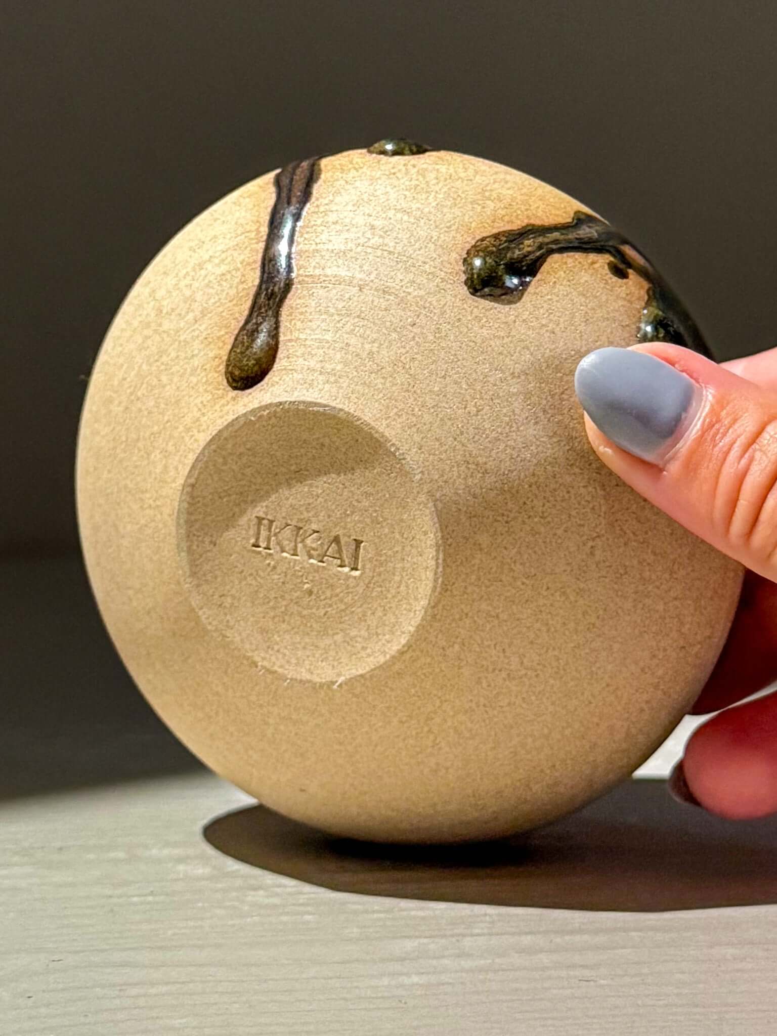 Handmade ceramics of an Orb Vase – Tenmoku #10 with unique glaze patterns, showcasing its sculptural design.