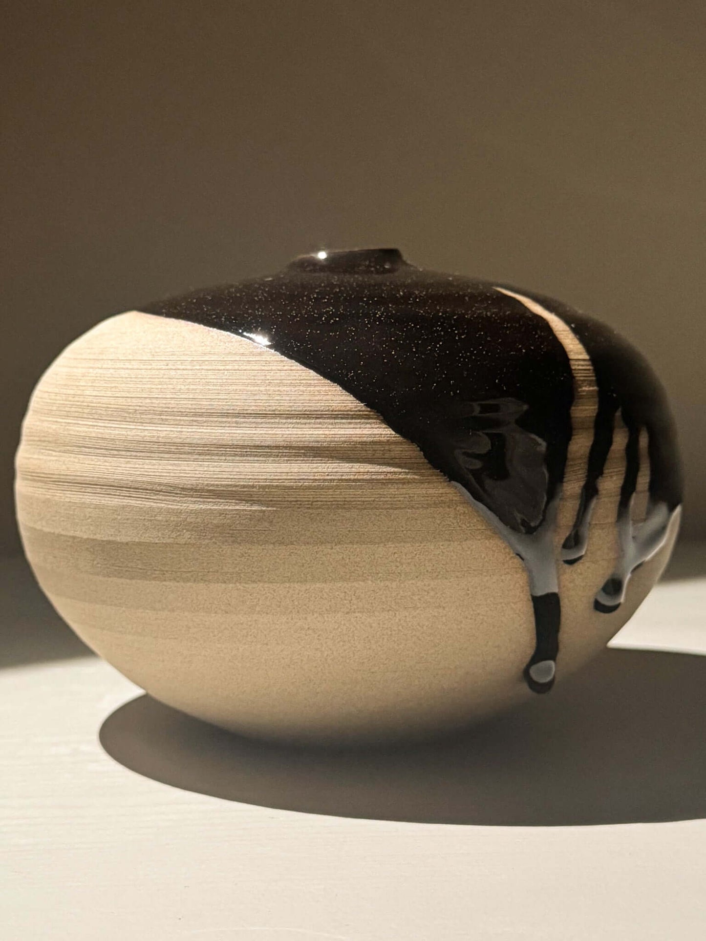 Orb Vase – Kuro #0 features a unique design with a smooth, rounded shape and distinctive glaze patterns.