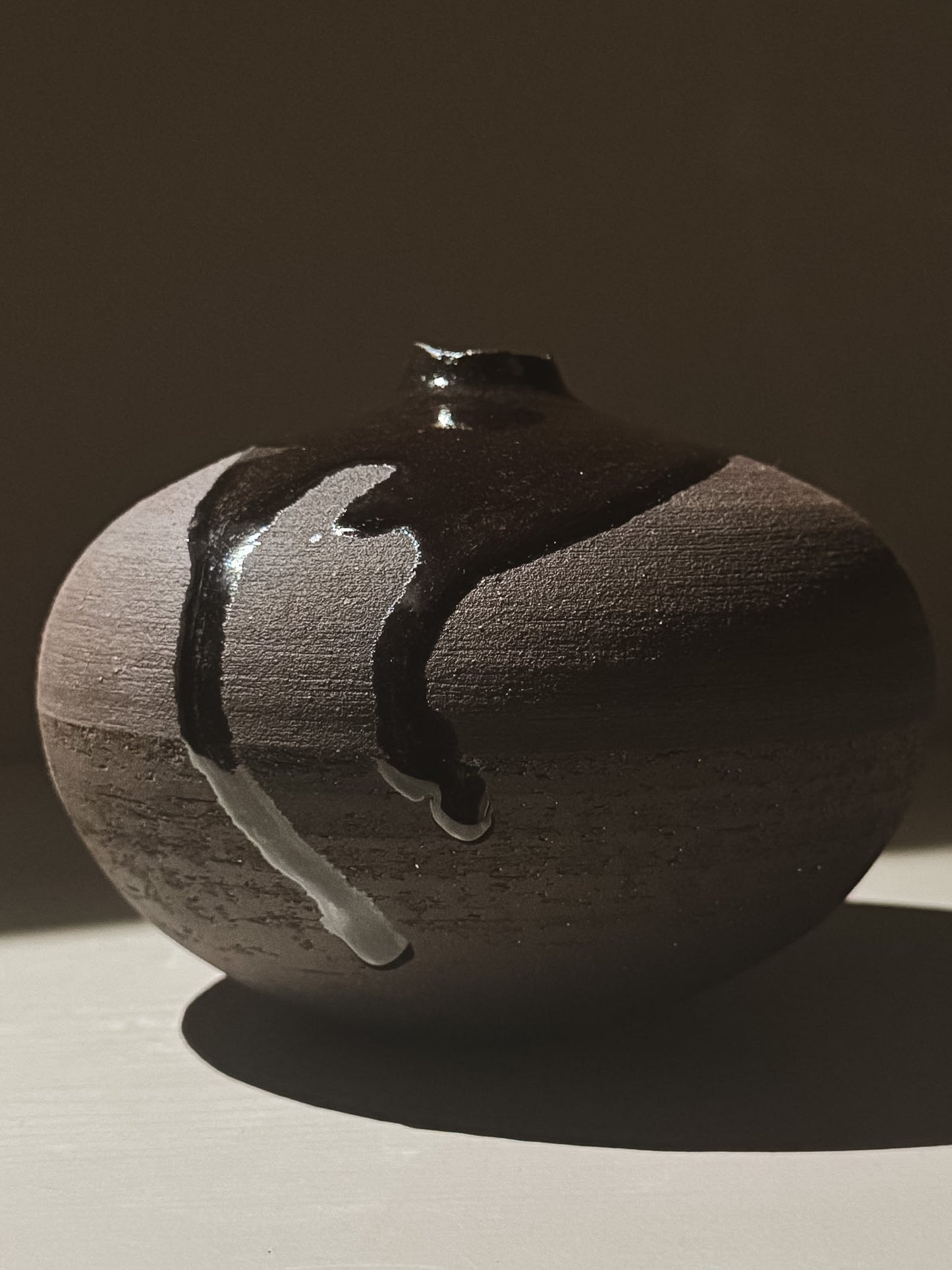 Orb Vase – Kuro Black #01 showcasing a unique glaze pattern and soft spherical form against a neutral background.