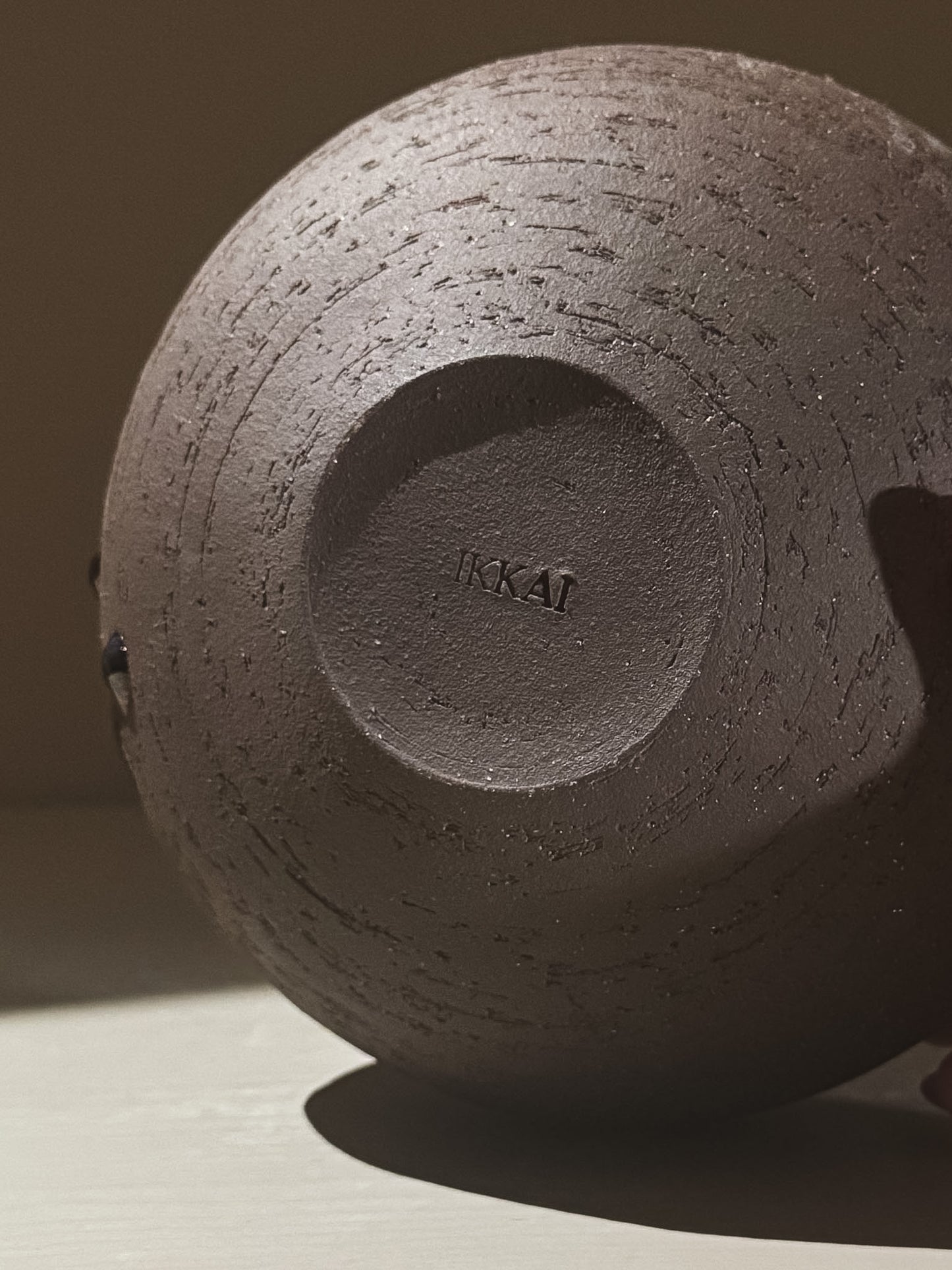 Bottom view of the Orb Vase – Kuro Black #01, showcasing unique texture and IKAI branding.