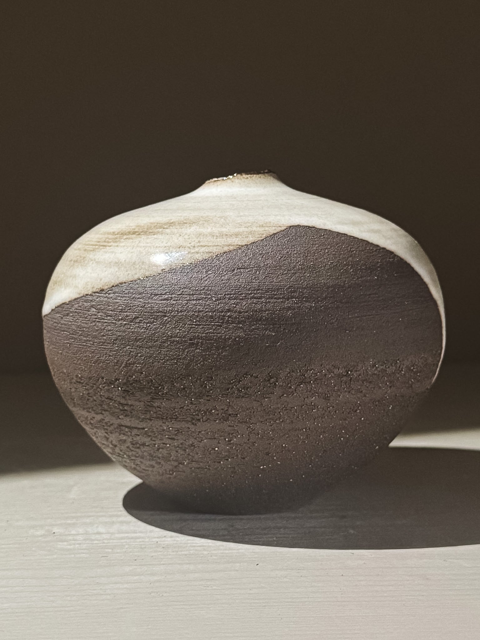 Orb Vase – Yuki Black #04 displayed against a neutral backdrop, showcasing its unique clay and glaze details.