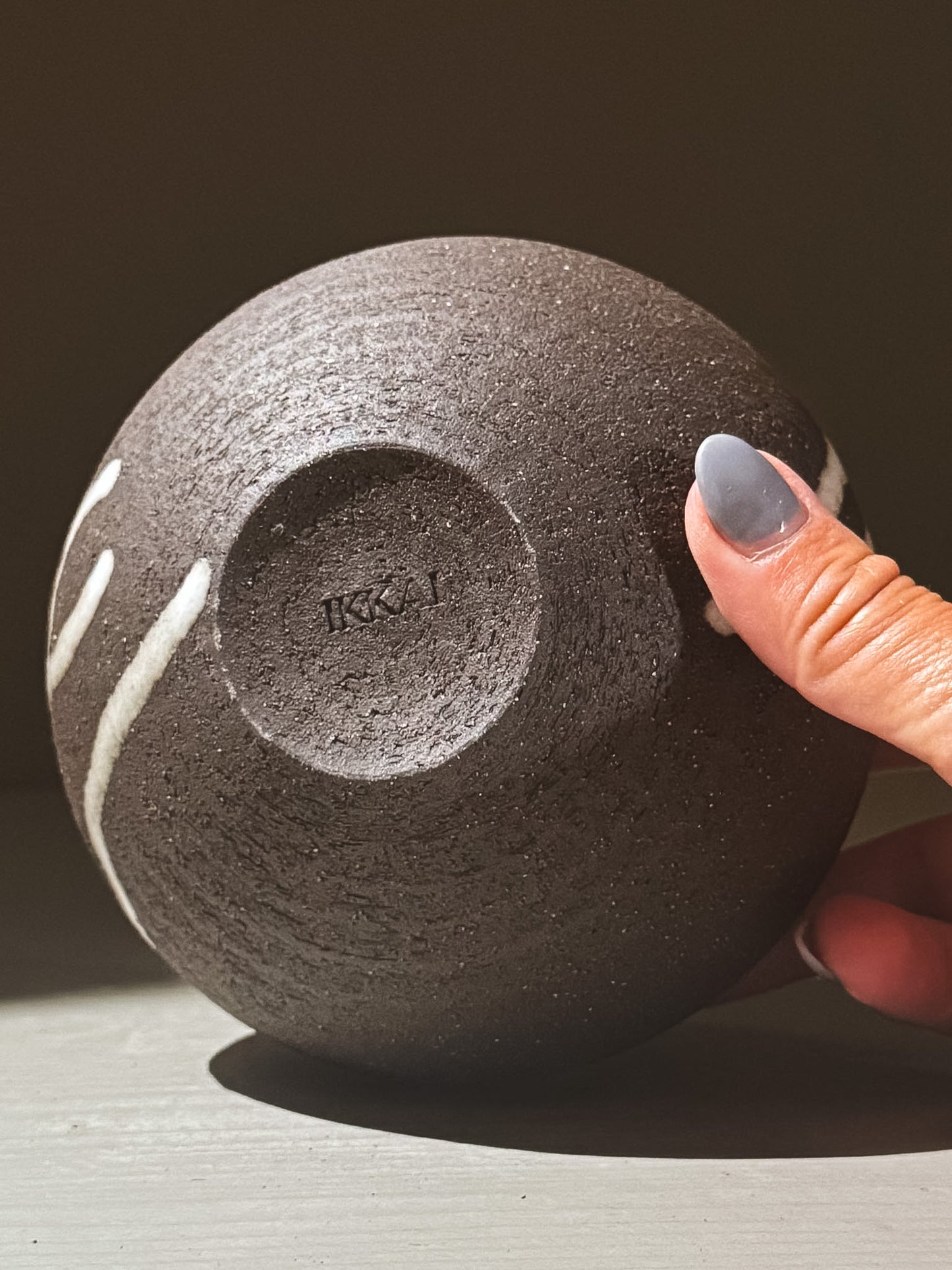 Orb Vase – Yuki Black #05 displayed from below, showcasing unique glaze movement and textured finish.
