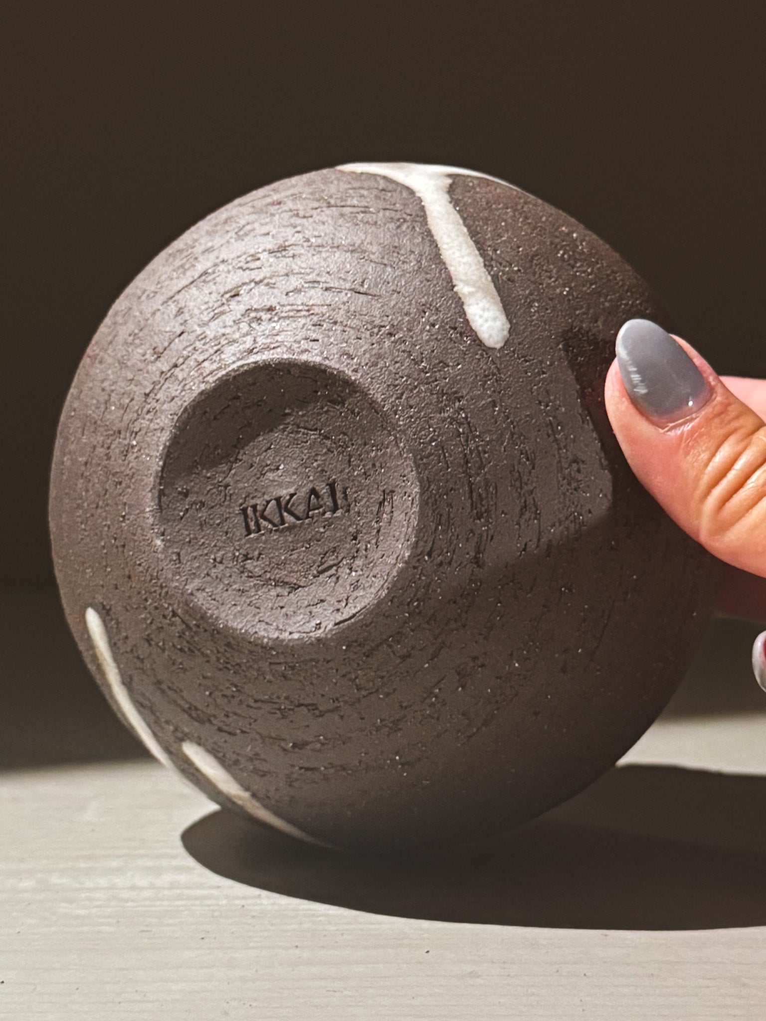 Orb Vase – Yuki Black #08 showing unique glaze patterns and rounded shape, held in hand.