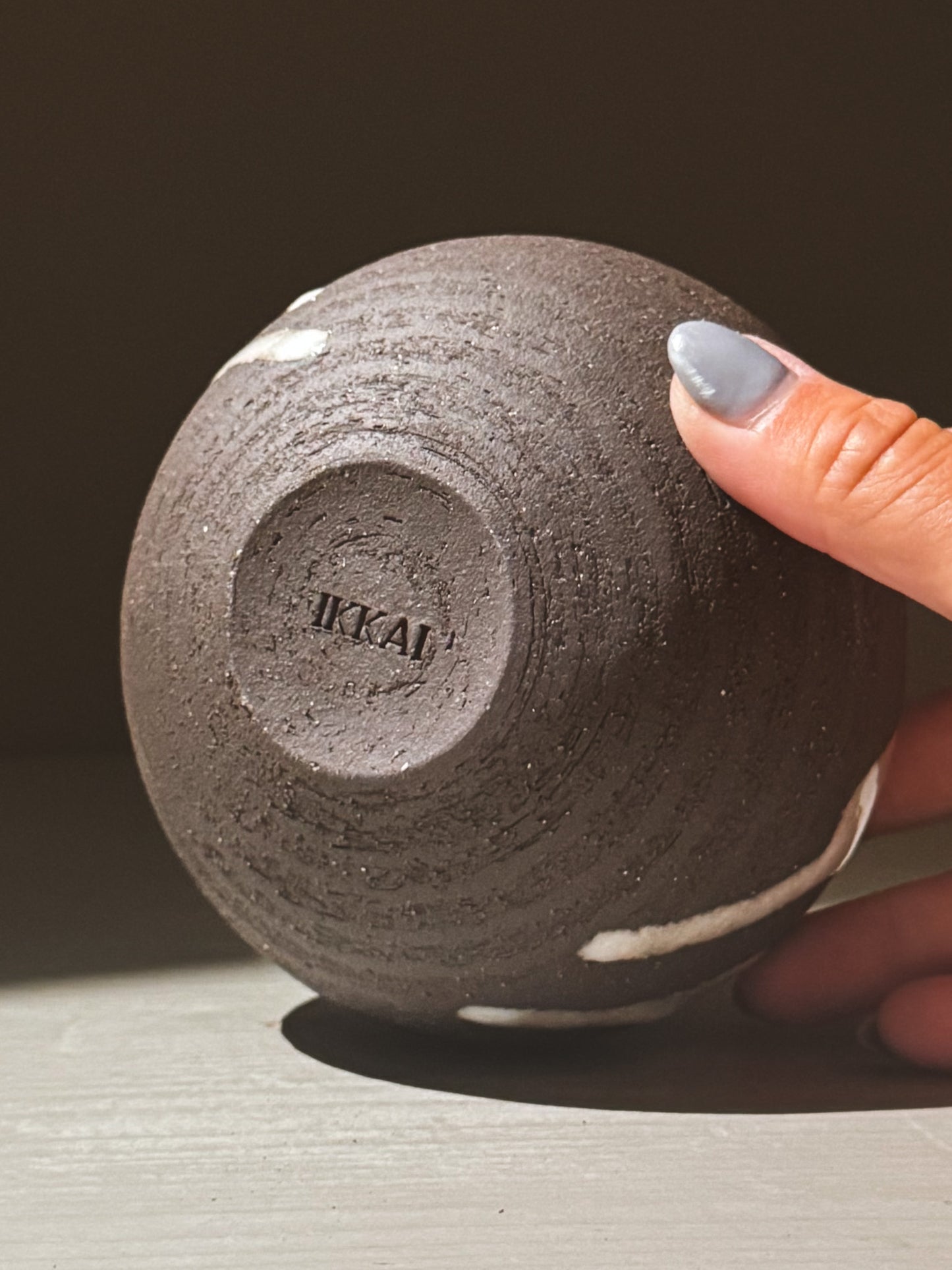 Orb Vase – Yuki Black #09 showing unique glaze patterns and rounded form, held in hand for scale.