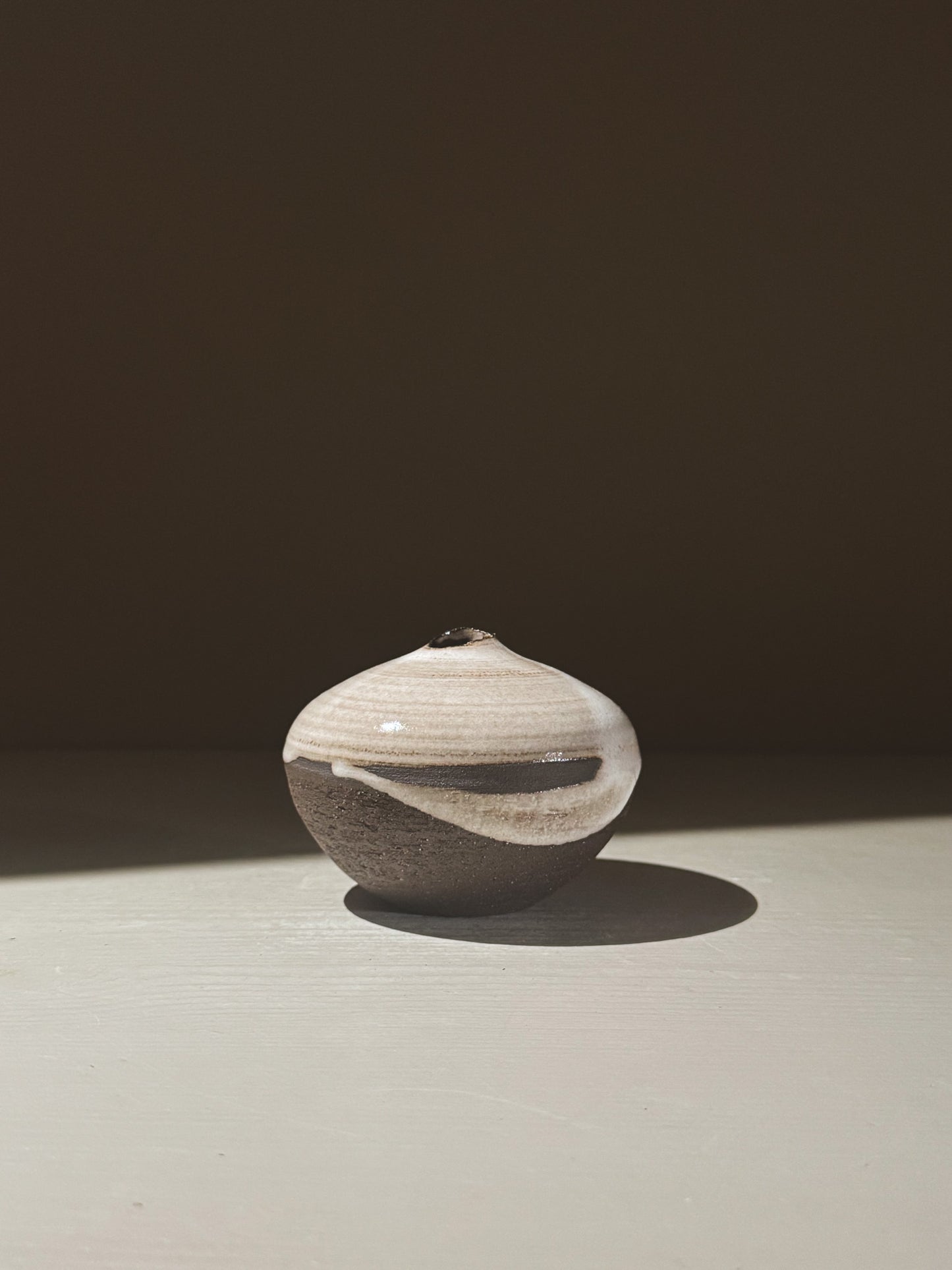 Orb Vase – Yuki Black #11 with unique glaze patterns and soft spherical form, showcasing a serene sculptural presence.