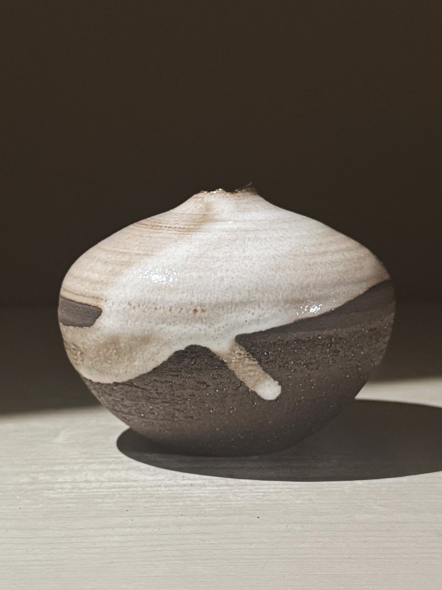 Orb Vase – Yuki Black #11, a unique rounded ceramic vase with organic glaze patterns and a soft sculptural design.