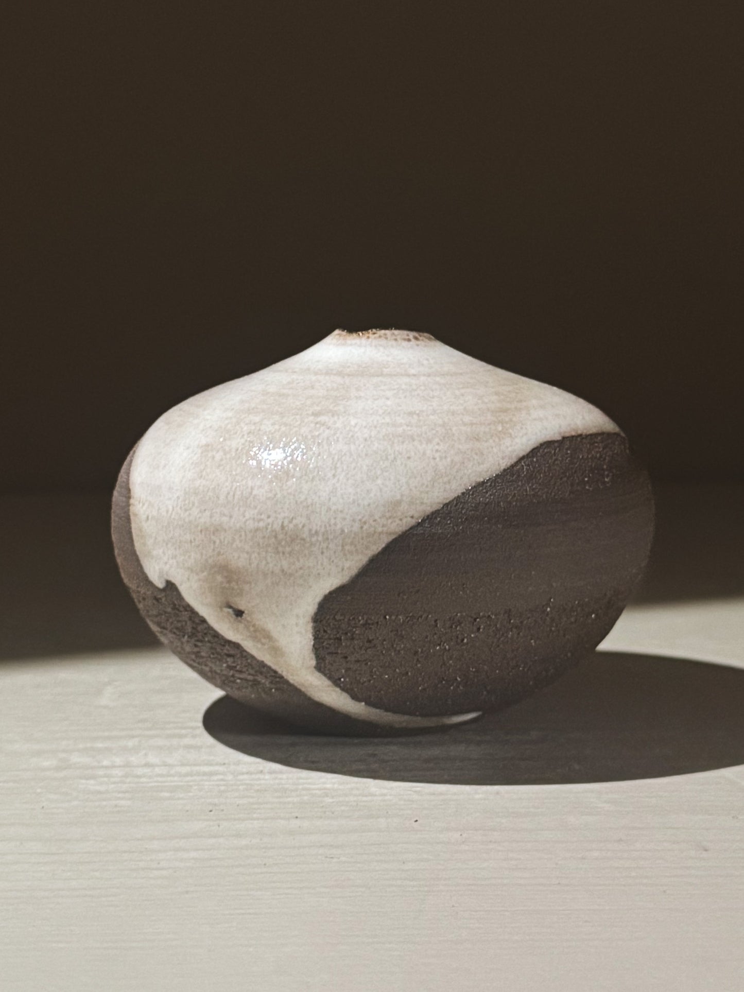 Orb Vase – Yuki Black #12, a unique rounded ceramic vase with natural glaze movement and soft sculptural form.