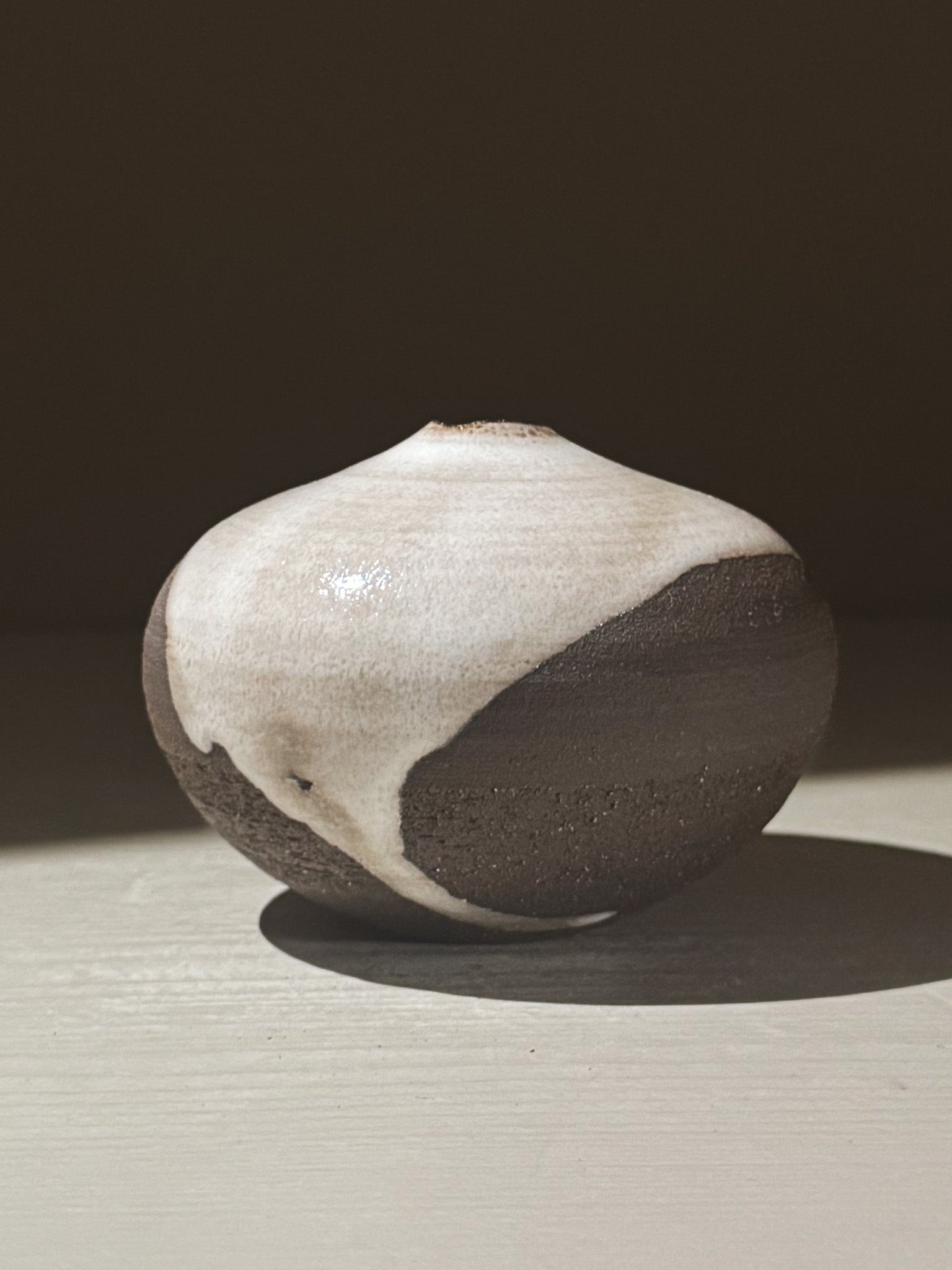 Orb Vase – Yuki Black #12, a unique rounded ceramic vase with natural glaze movement and soft sculptural form.