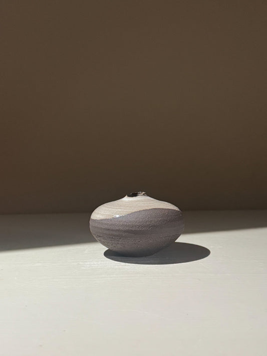 Orb Vase – Yuki Black #13 showcasing a soft spherical form with unique glaze patterns on a simple background.
