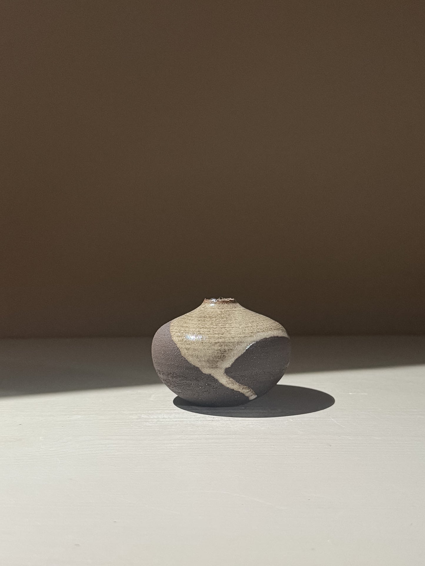 Orb Vase – Yuki Black #14 showcasing unique clay and glaze patterns, featuring a soft spherical form.