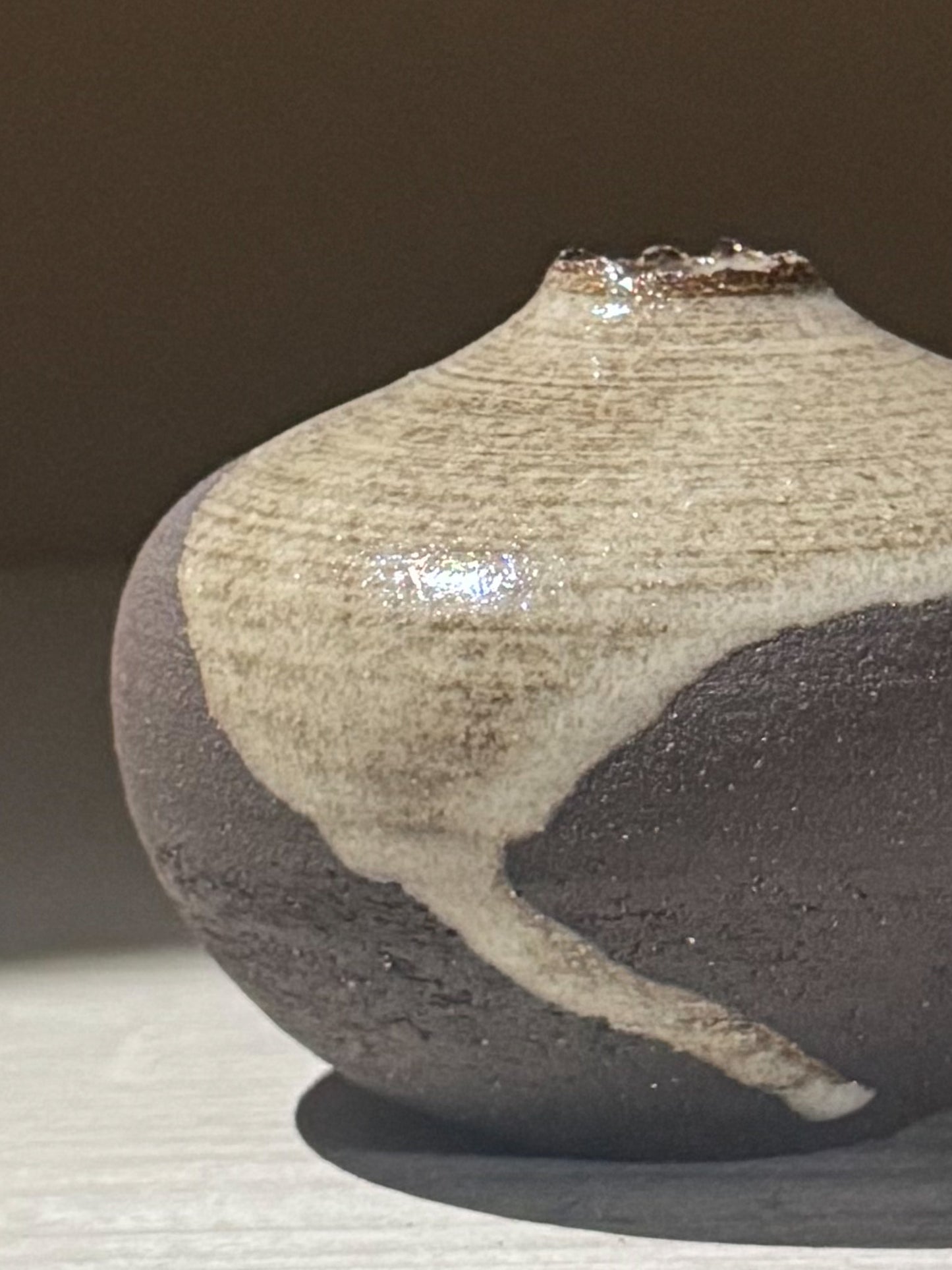 Close-up of an Orb Vase – Yuki Black #14 featuring a unique glaze pattern and soft spherical form.