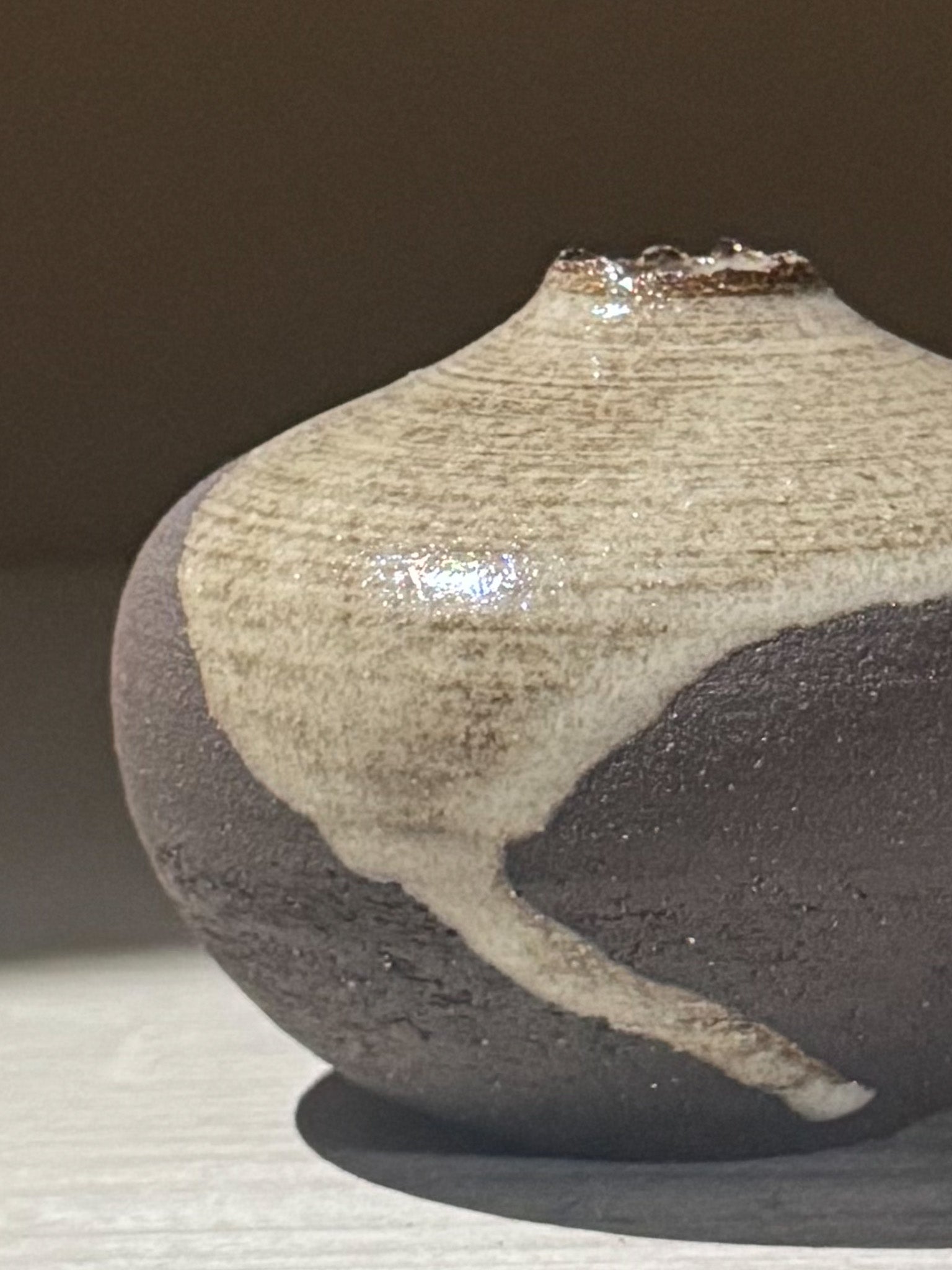 Close-up of an Orb Vase – Yuki Black #14 featuring a unique glaze pattern and soft spherical form.