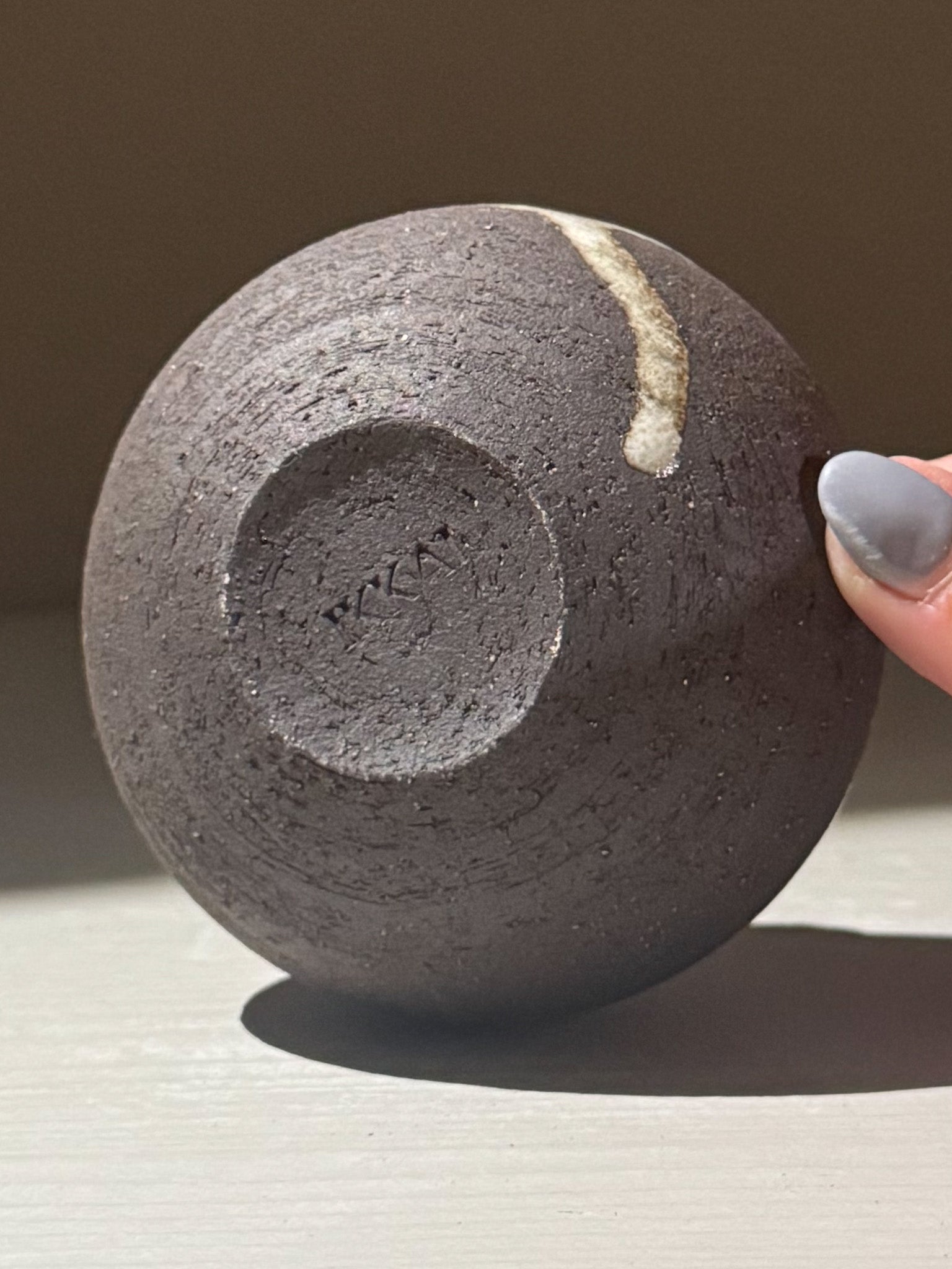 Orb Vase – Yuki Black #14, a unique rounded pottery piece showcasing organic glaze movement and sculptural design.