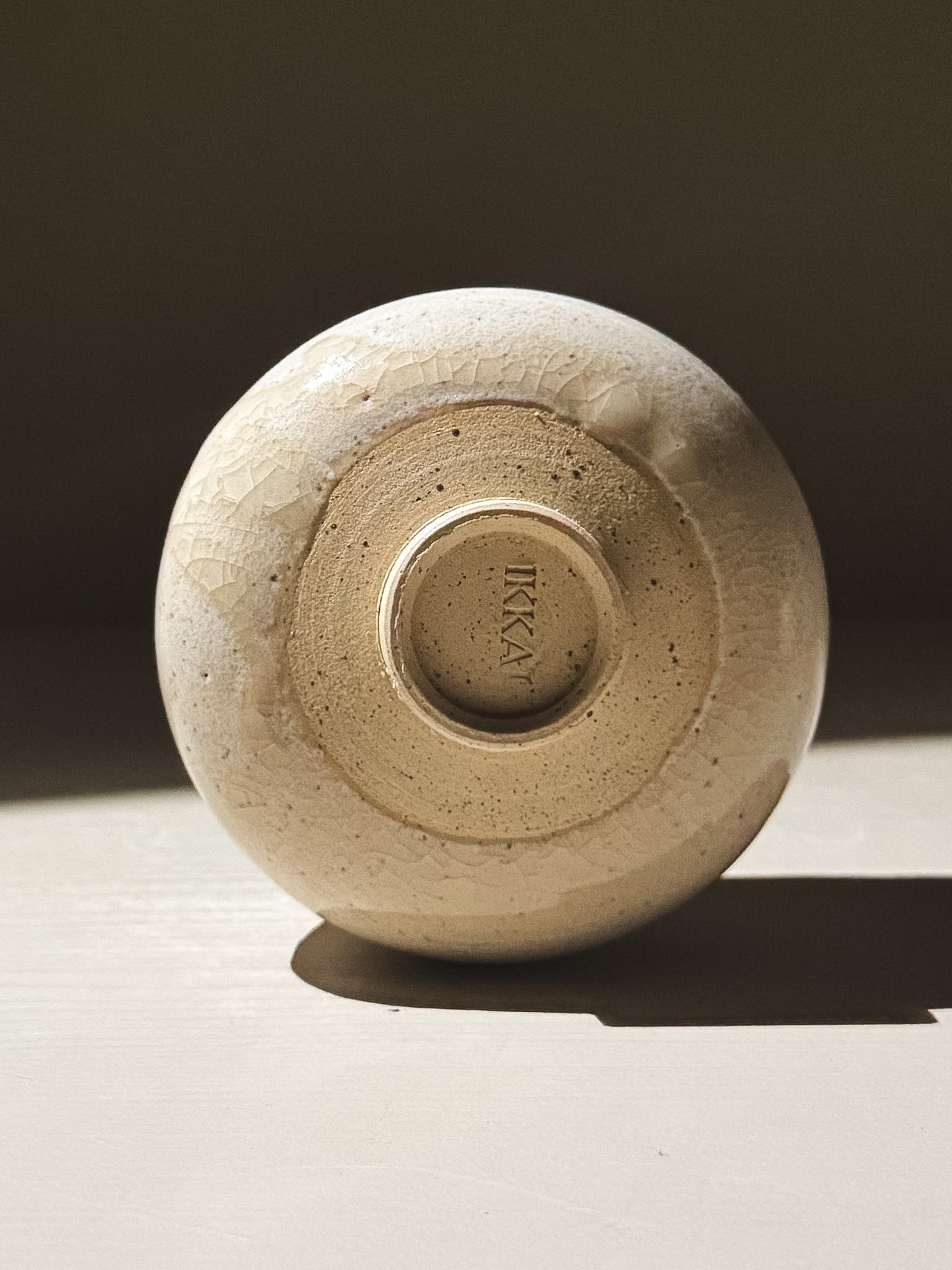 Yunomi Cup - Kannyū Series  #11 base showing elegant crackle glaze and IKKA imprint in soft light.