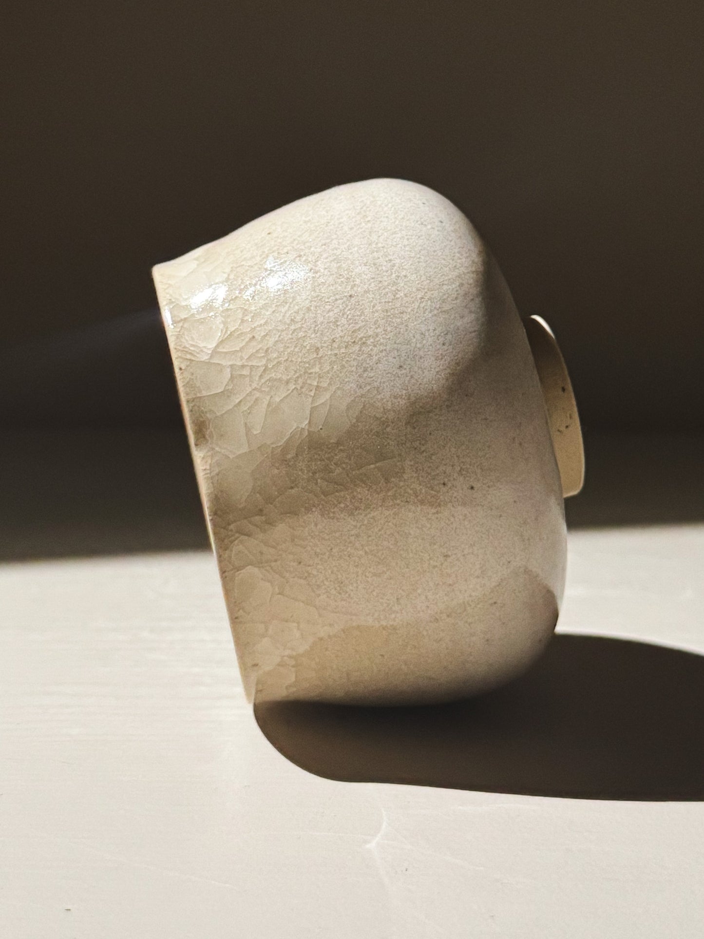 Yunomi Cup - Kannyū Series  #12 with a crackle glaze finish reflecting light.