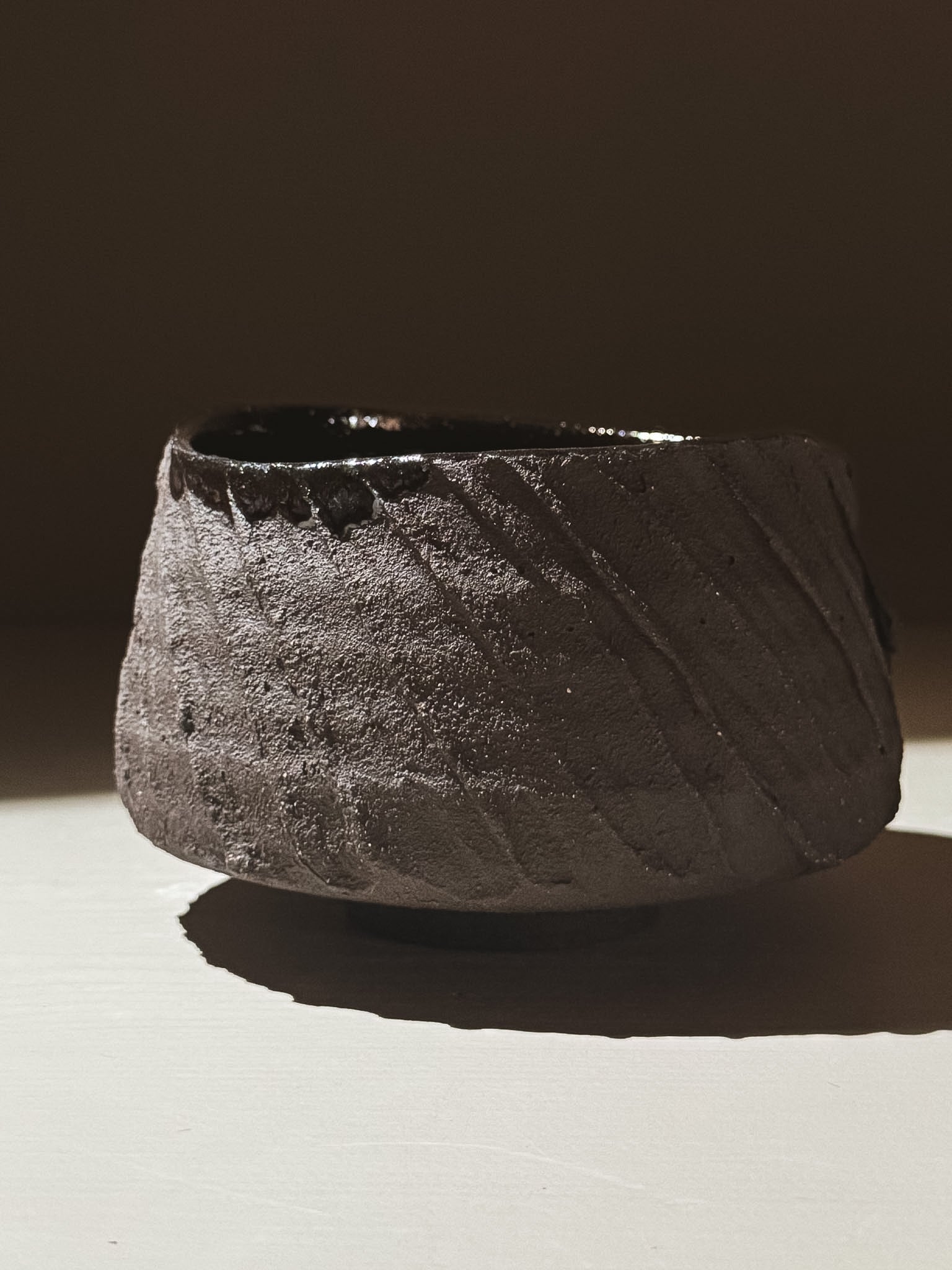 Kuro Matcha Bowl #02 featuring textured dark brown exterior and glossy black interior, inspired by volcanic stone.