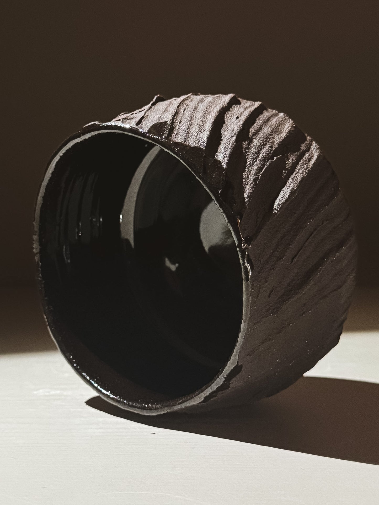 Kuro Matcha Bowl #02 showcasing a textured dark brown exterior and glossy black interior, inspired by volcanic stone.