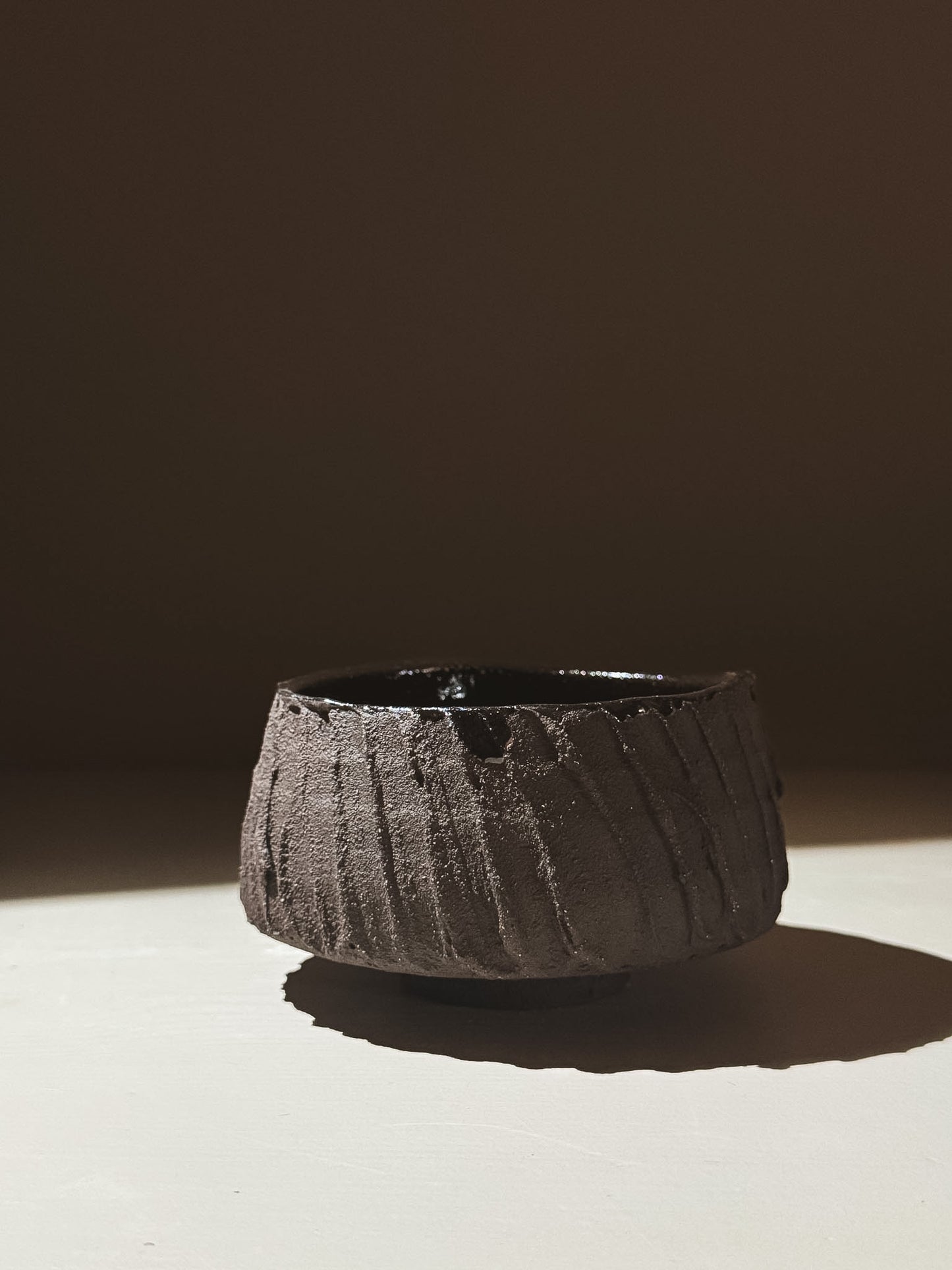 Kuro Matcha Bowl #03 with rough textured dark brown exterior and glossy dark interior, inspired by volcanic stone.